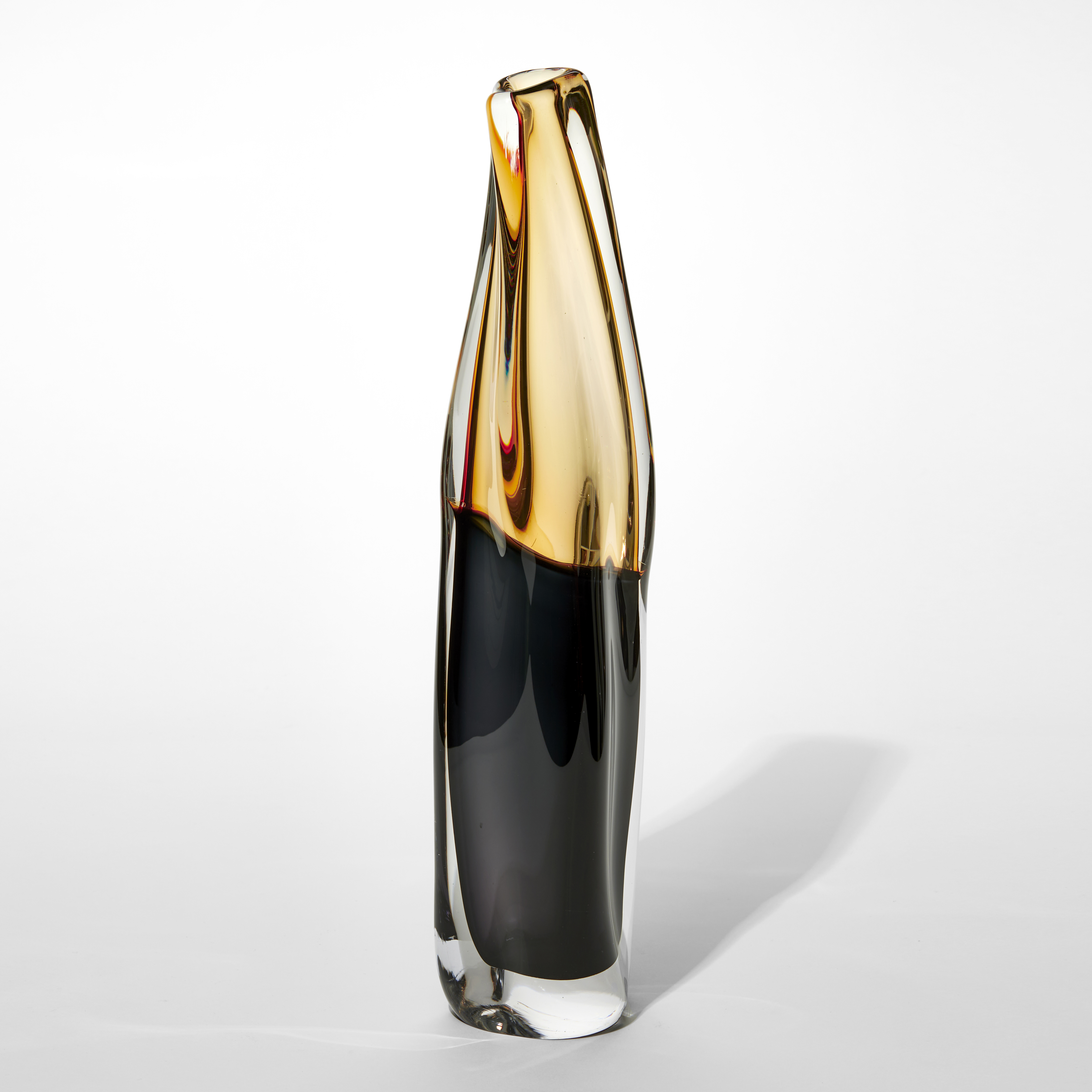 standing lozenge shaped vessel with small top opening fluid slightly twisting lines and the top half in soft amber and the  bottom in dense black hand made from glass