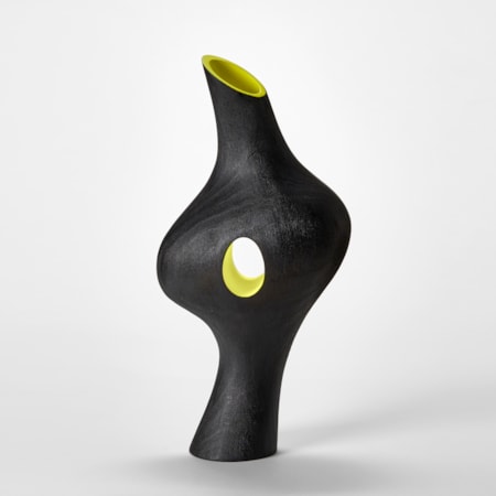 tall elegant black sculpture with bulging waist and sweeping curved profile with acid yellow lined central hole piercing through and top similarly coloured angled opening