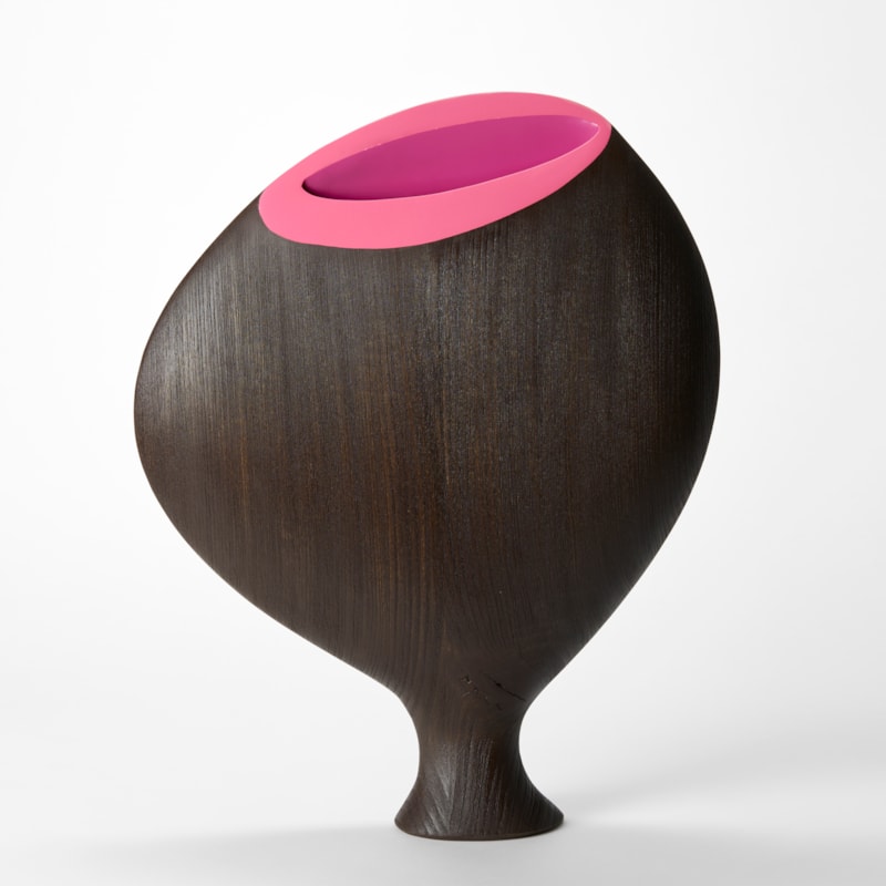 wide rounded vessel with two flattish sides perched on a narrow taped foot hand made from dark tulip wood with top elliptical bright pink opening