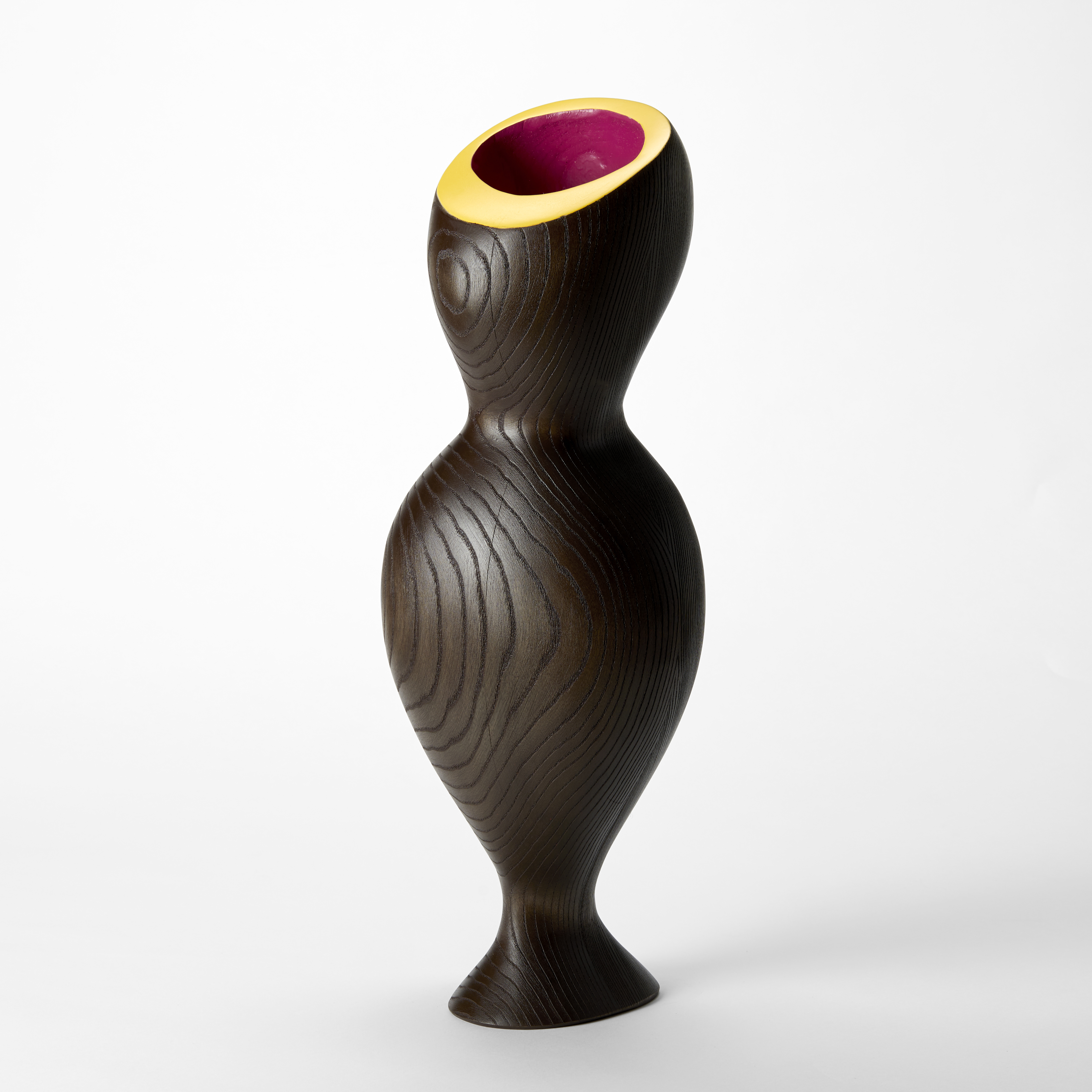 undulating hour glass shaped wooden sculpture with ridged contour lined surface and top opening with a flat angled rim in bright yellow and inner cavity in bright pink