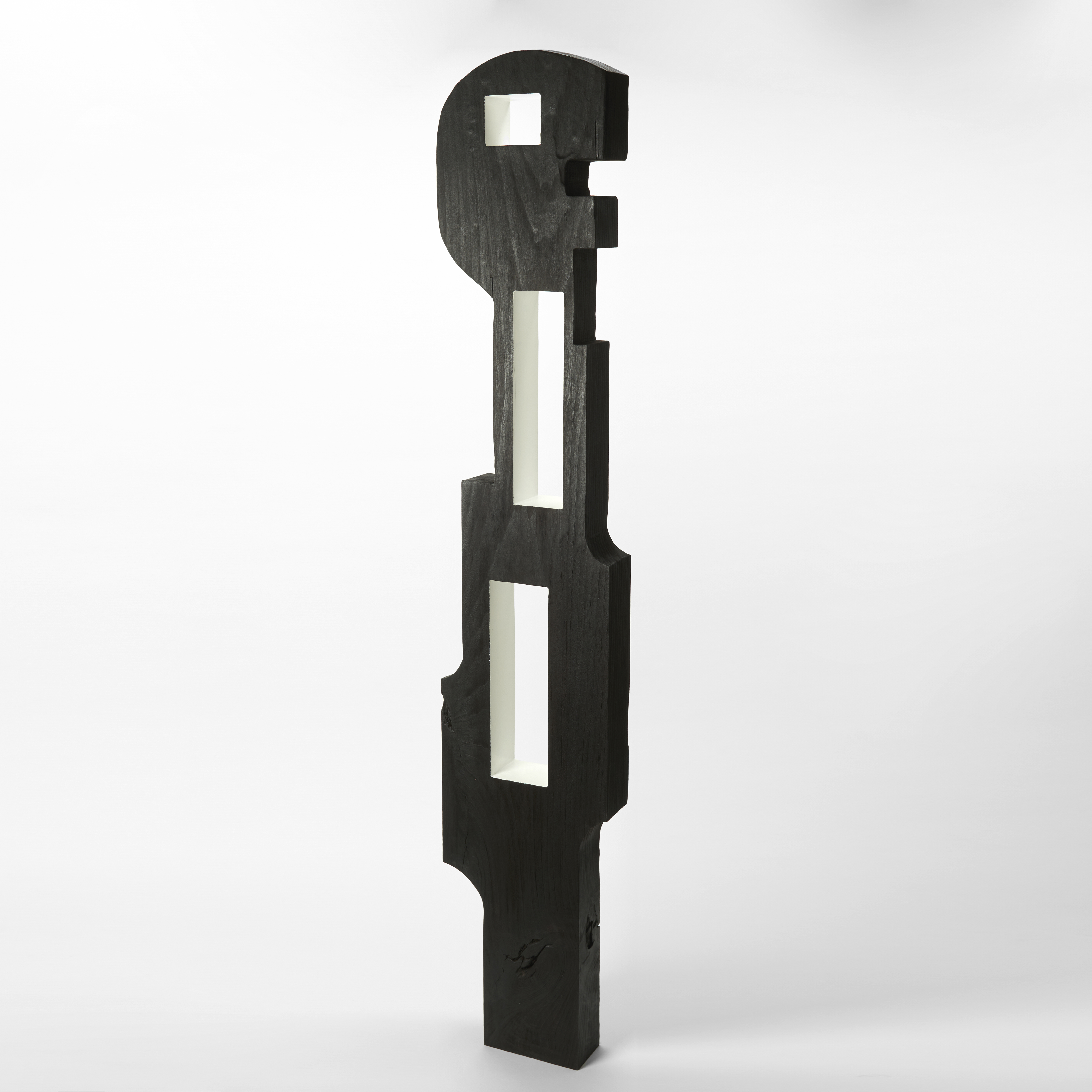 monochrome black and white tall standing abstract figure with stylised graphic form and angular silhouette with a flat front and back and two rectangular windows through the torso hand made from tulip wood