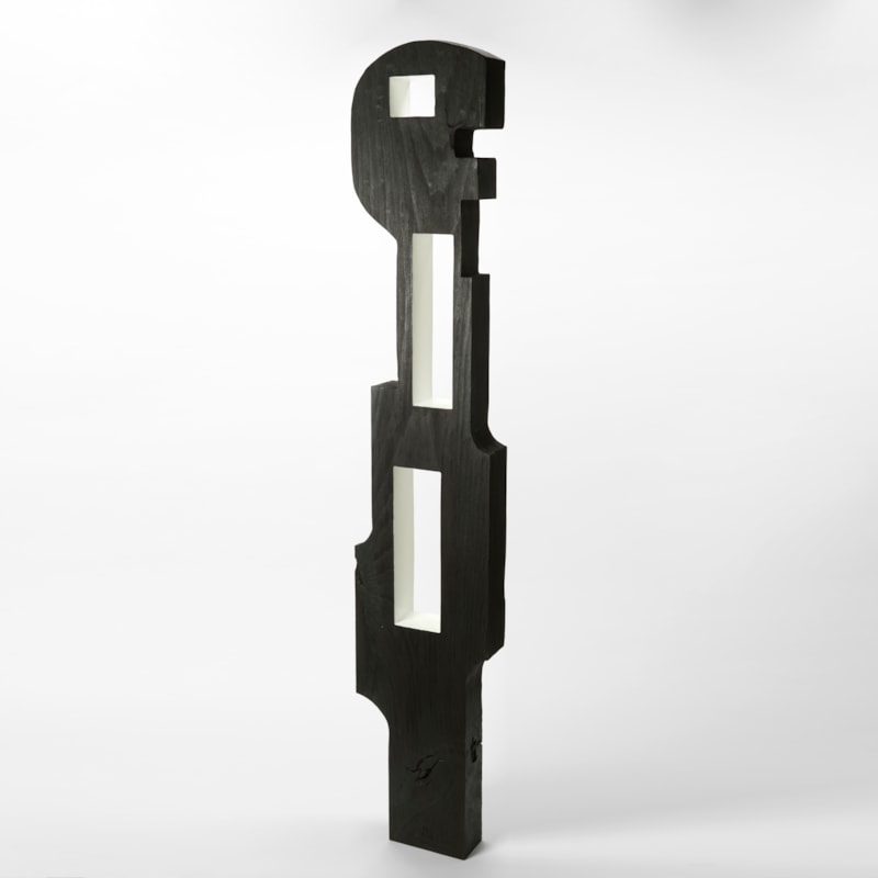 monochrome black and white tall standing abstract figure with stylised graphic form and angular silhouette with a flat front and back and two rectangular windows through the torso hand made from tulip wood