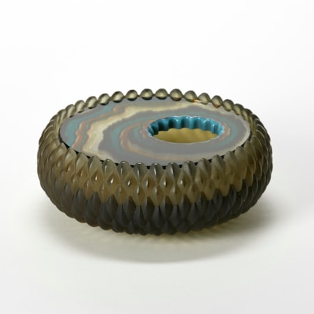 round low box with curved sides and an opaque matt exterior surface with a relief repeat diamond pattern in bronze olive green and an inset polished lid with organic bands of colour in rust black jade green and brown hand made from glass