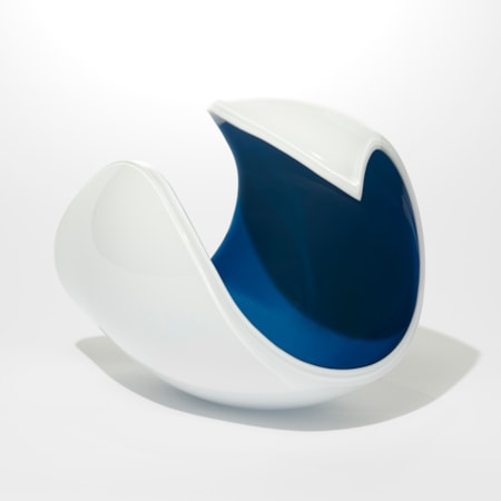 rounded form with opaque white exterior and dark midnight blue interior with a curved rim curling to a final point like the golden section hand made from glass