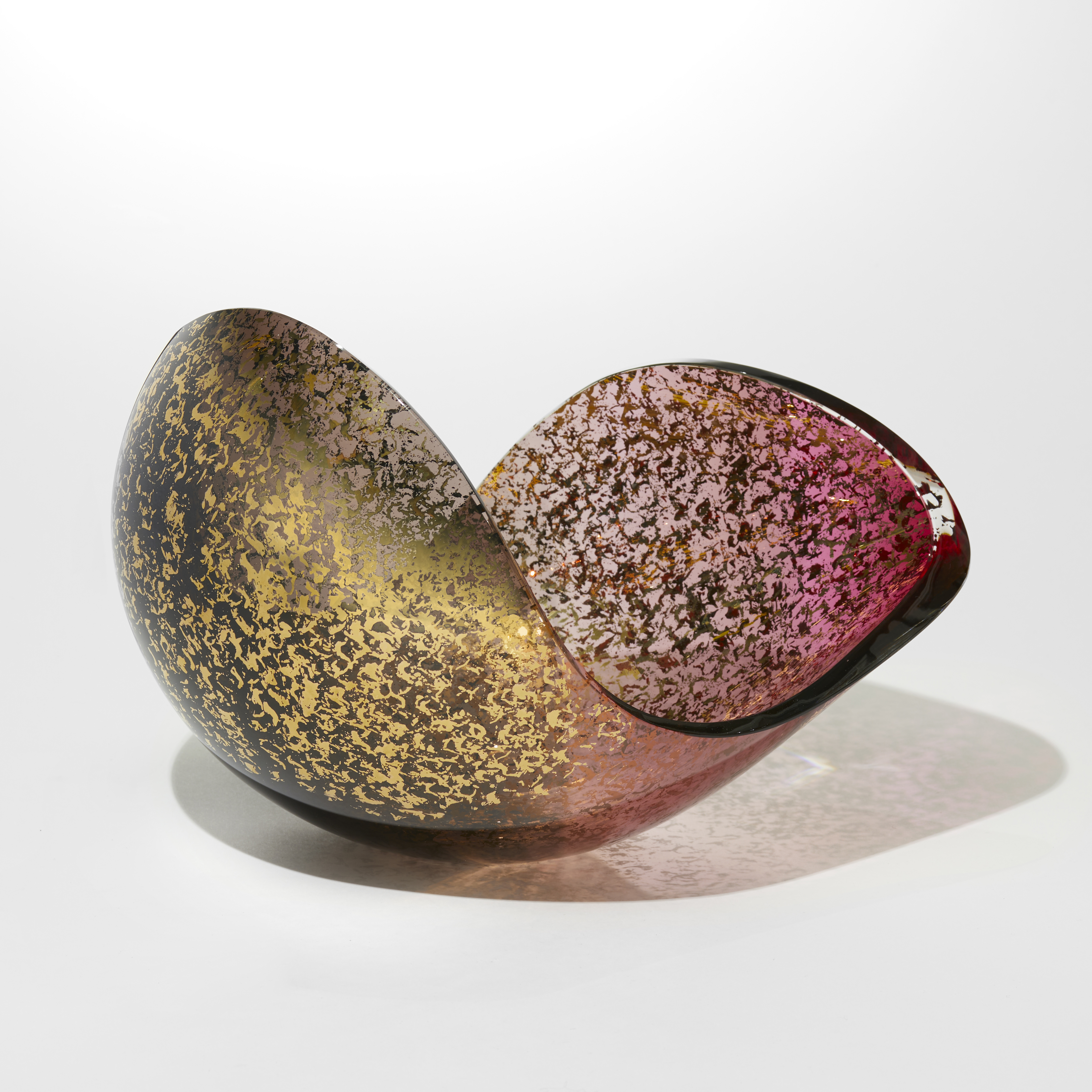 open topped ovoid sculpture with elliptical curved rim made from transparent pink and purple glass with a gold organic texture on the outside