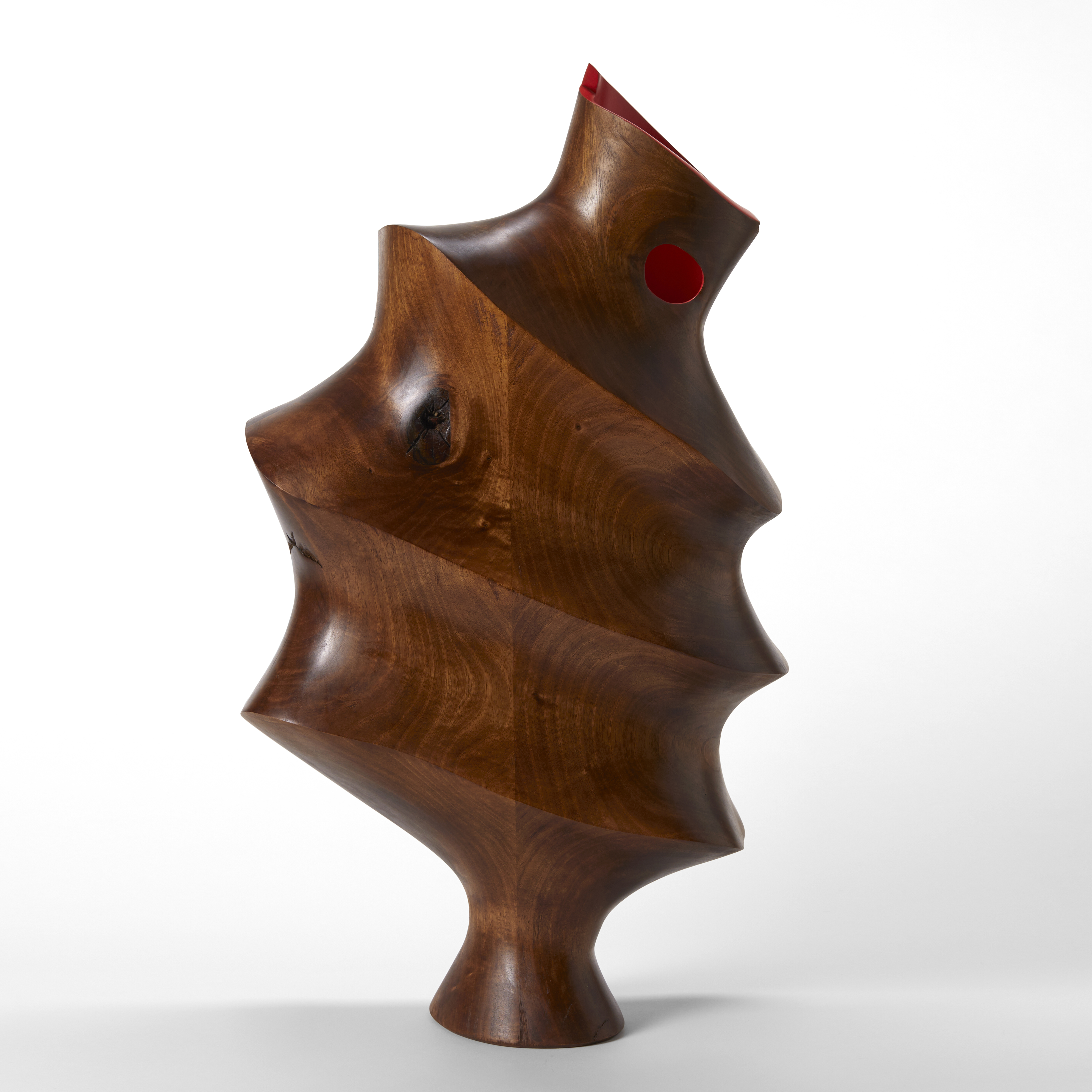 tall sculptural vessel made from walnut wood with narrow flared base and concertina sections with a top opening and red interior