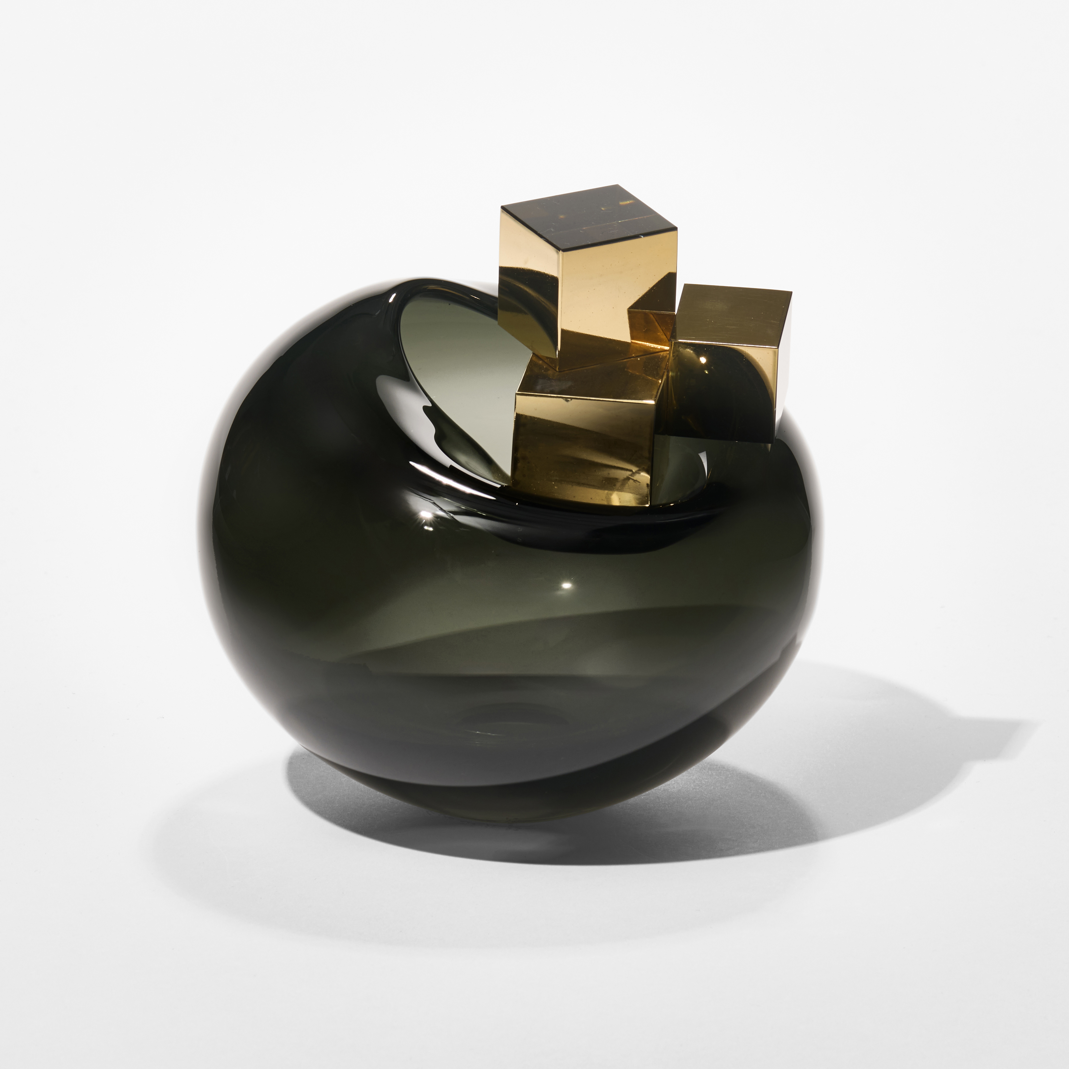 round dark grey glossy transparent bubble with three different sized gold cubes balanced on the top hand blown from glass with gold lustre