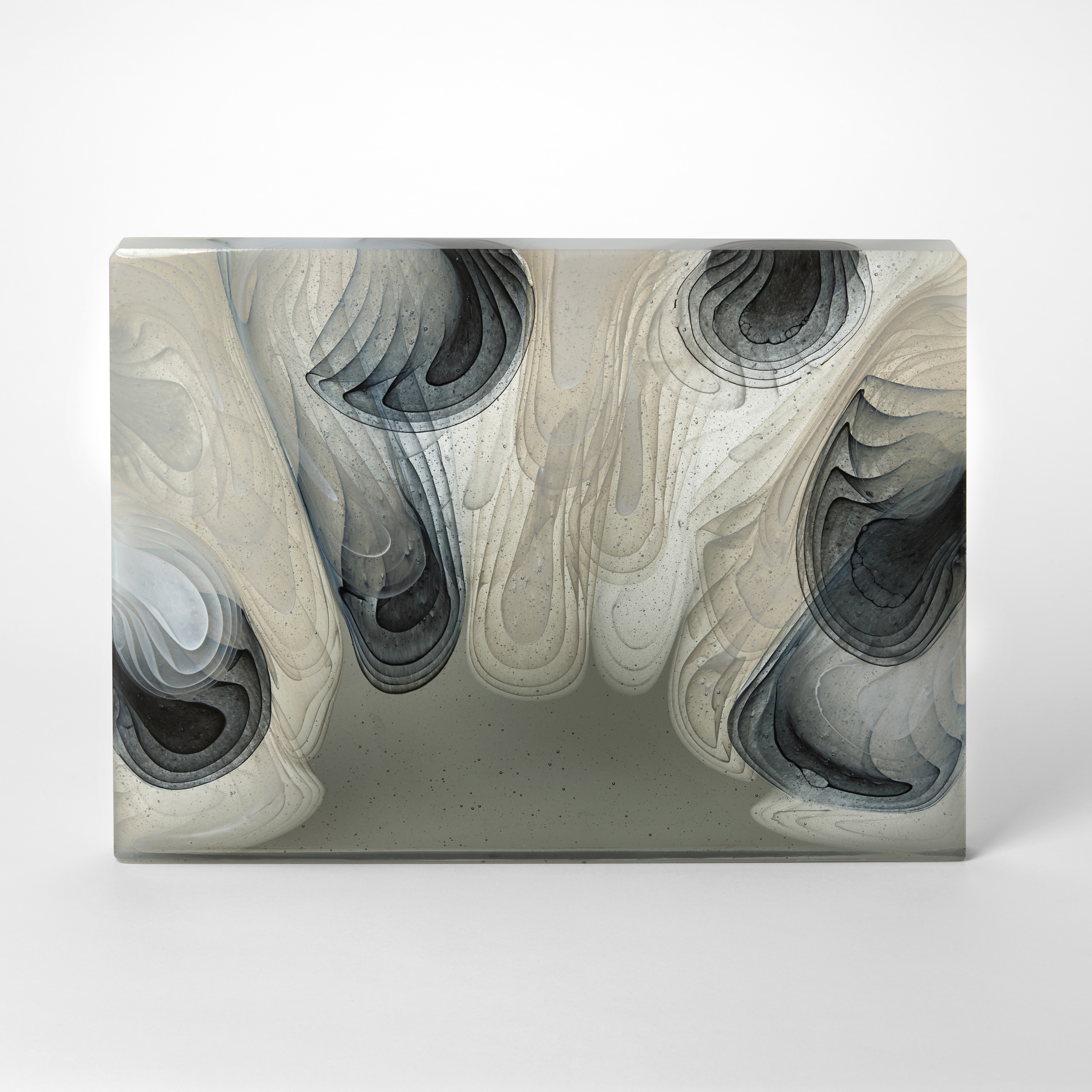 rectangular semi transparent glossy thick block with concentric downward flat amorphic shapes and droplets in grey mink and white hand made from cast glass