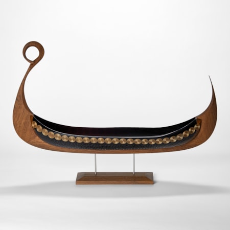 steel blue viking ship artwork with carved oak keel with ring detail at the front with a cut and blown glass hull with decorative patterns engraved on the surface presented perched on a simple stand