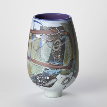tulip shaped vessel with tapering narrow elegant foot with a matt exterior covered in abstract flat linear patterns and lines in white olive midnight blue and ochre with a glossy purple interior hand made from glass
