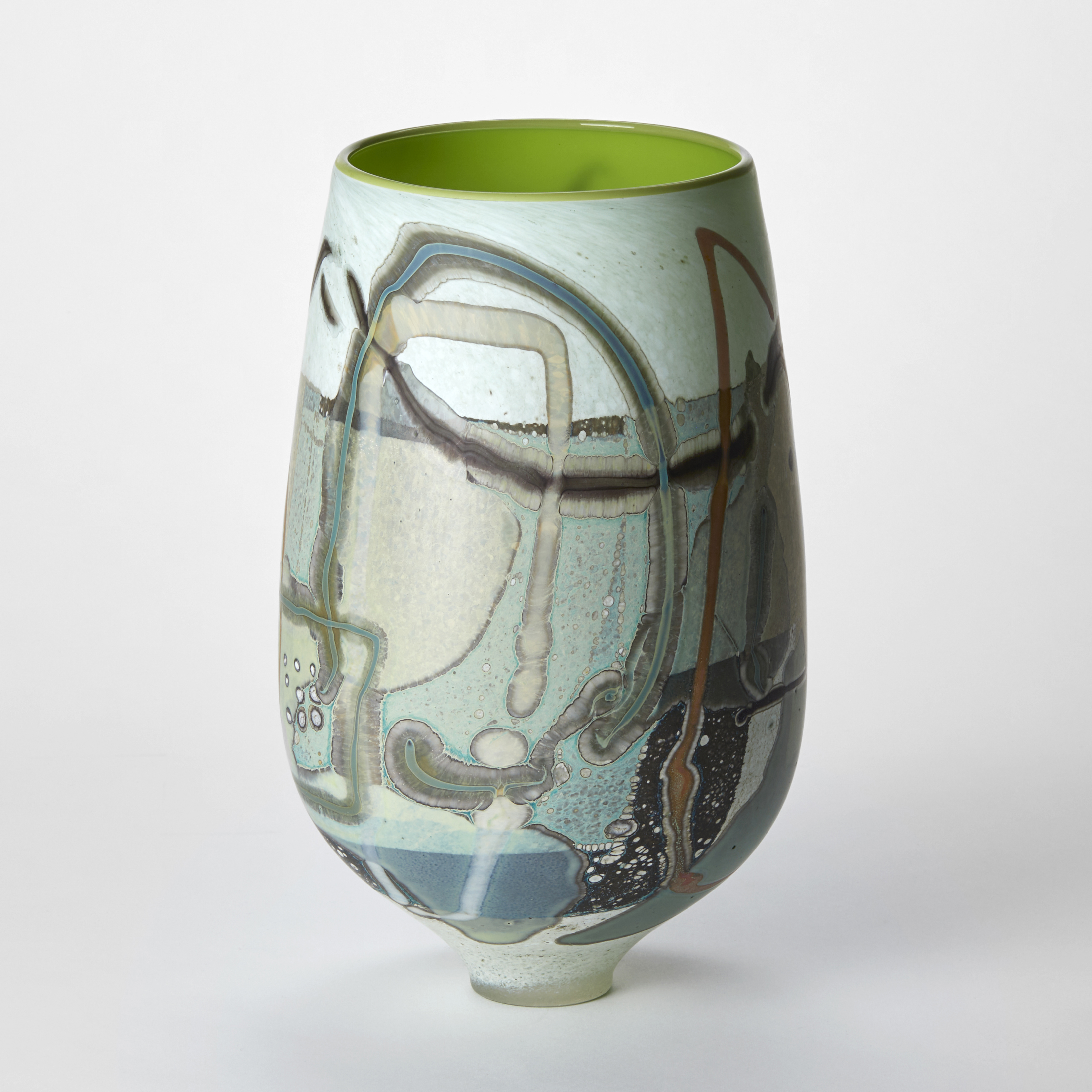 bulb shaped vase with narrowing tapered foot with the matt exterior covered in abstract and organic flat patterns in duck egg blue taupe dark jade and white with an interior in glossy lime green hand made from glass