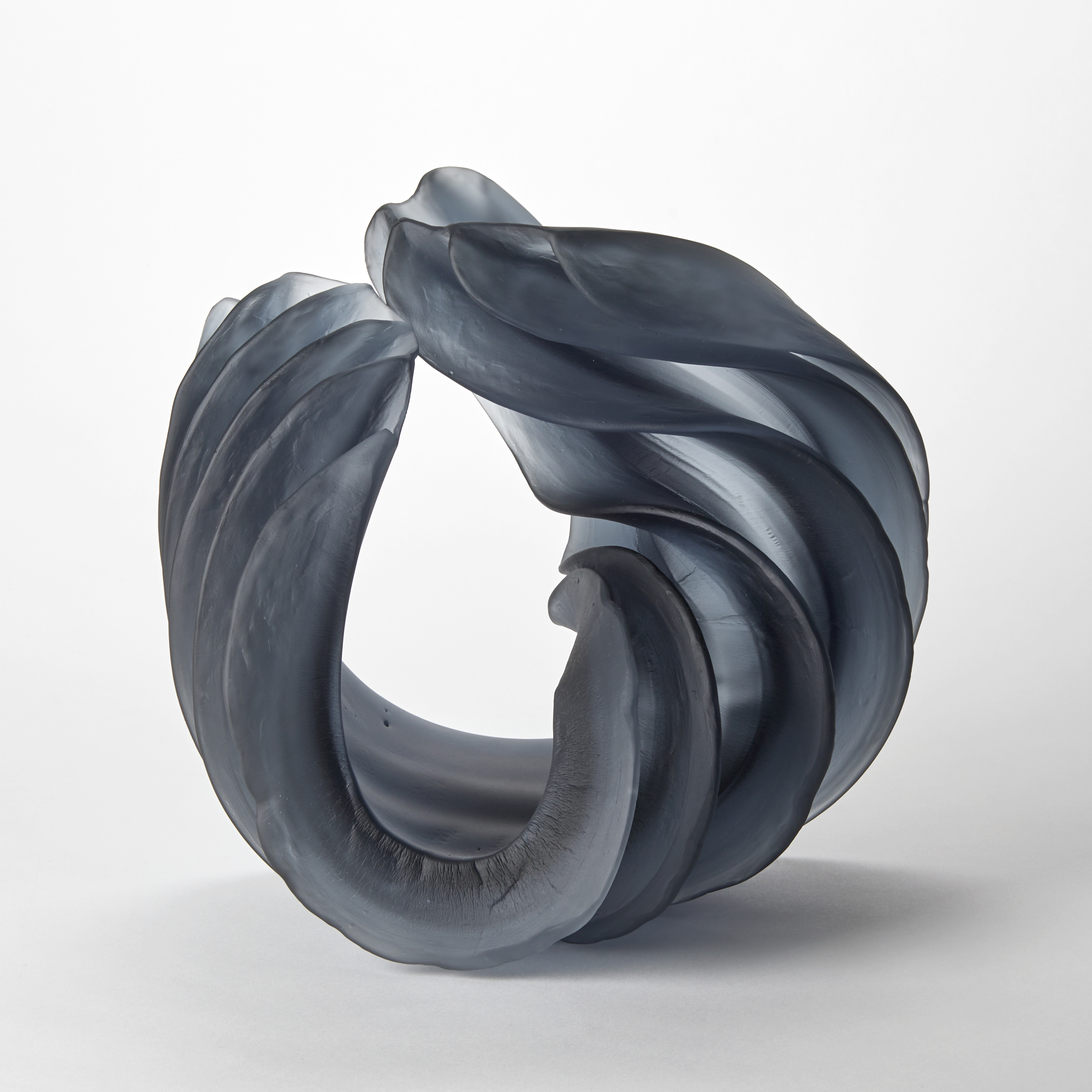 dense opaque slate steel grey thick curling form with deep evenly spaced ridges hand made from cast glass