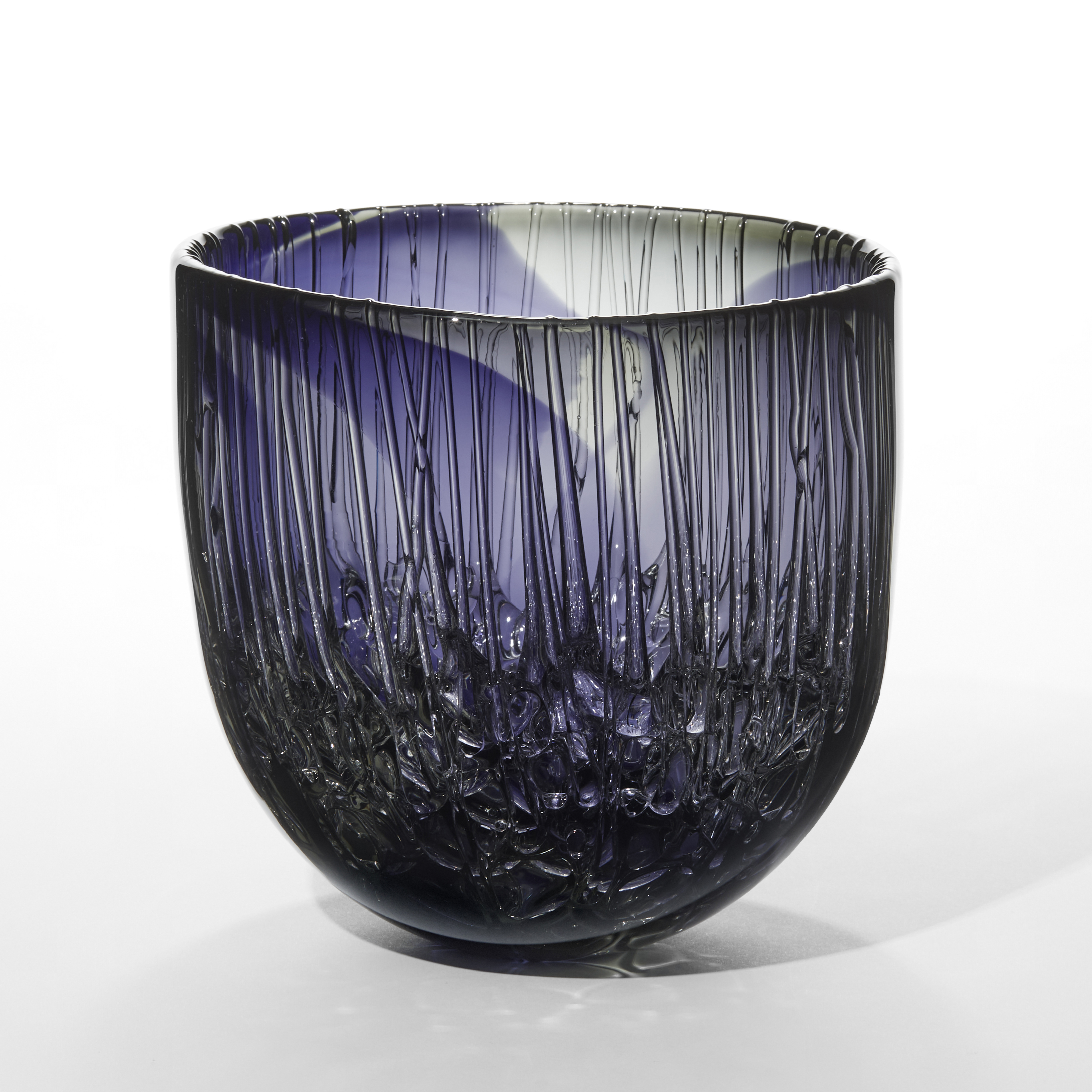 transparent hazy purple and grey bowl with a rounded base and glossy exterior with the inside covered with raised drips down the sides pooling in the bottom hand made from glass