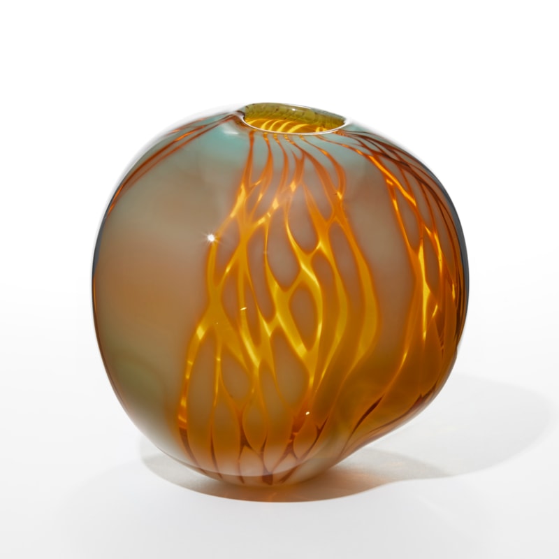 rich amber squished rounded vase with opaque teal and aqua patchwork sections on the surface hand made from glass