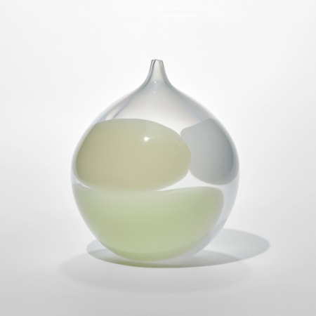 hand blown round dew drop shaped vessel with small pointed opening made from milky semi transparent glass with three rounded blobs on the surface in opaque white cream and yellow