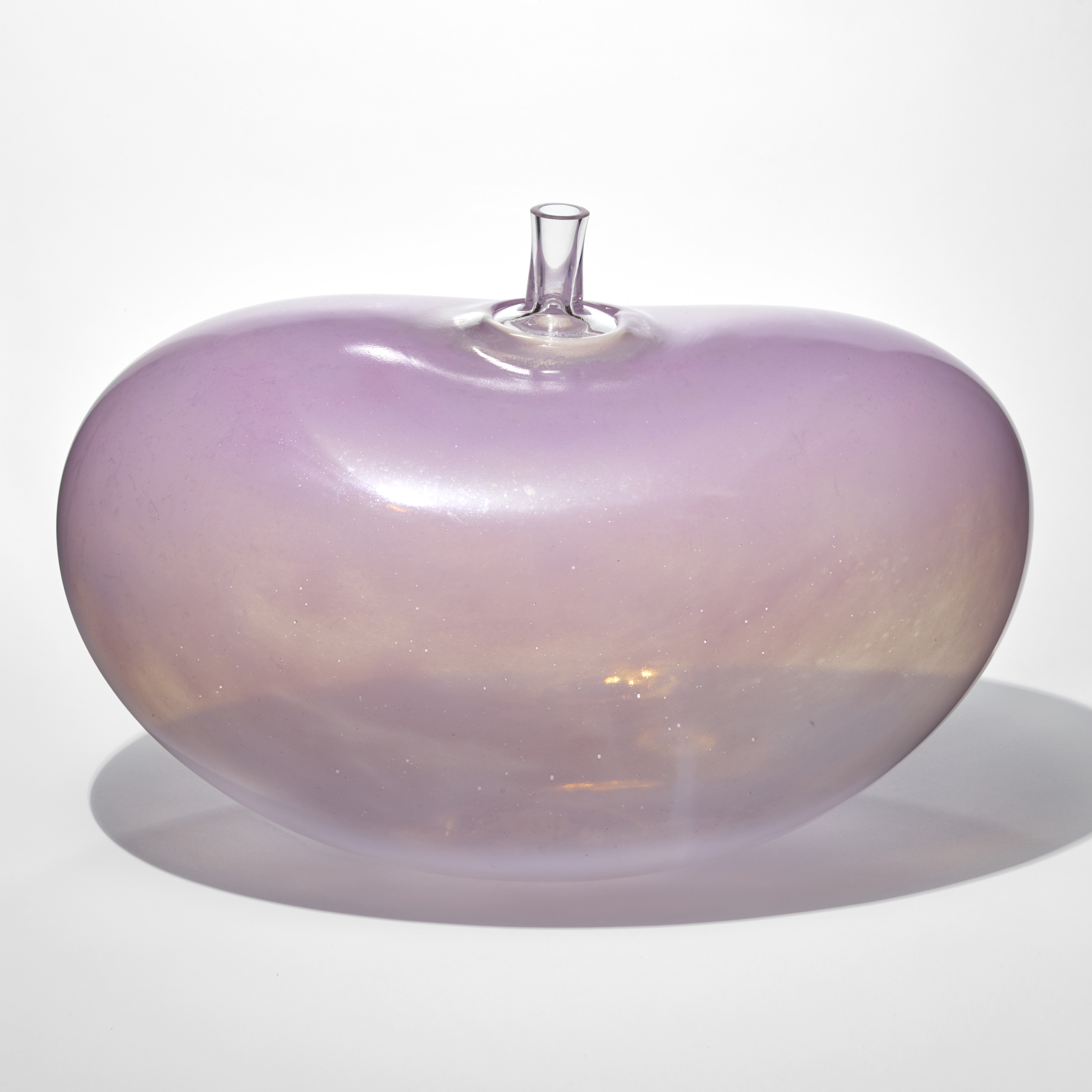 jelly bean shaped vessel with a transparent swirling bottom half and opaque top half in candy pink with a short tubular stem at the top hand made from glass
