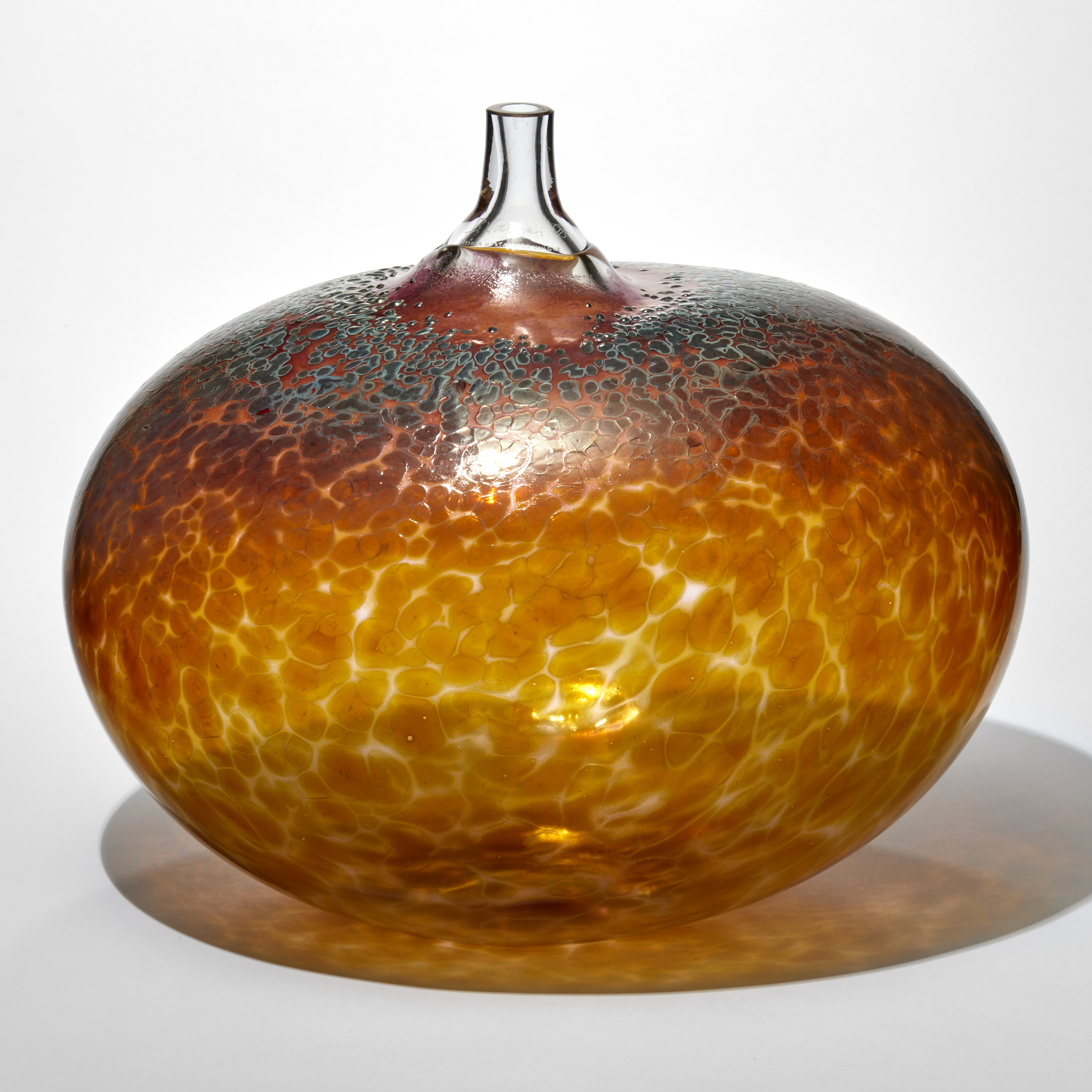 clear golden amber rounded bean shape sculptural vessel with a clear protruding tubular stem with a mottled dark amber and rust surface handmade from glass