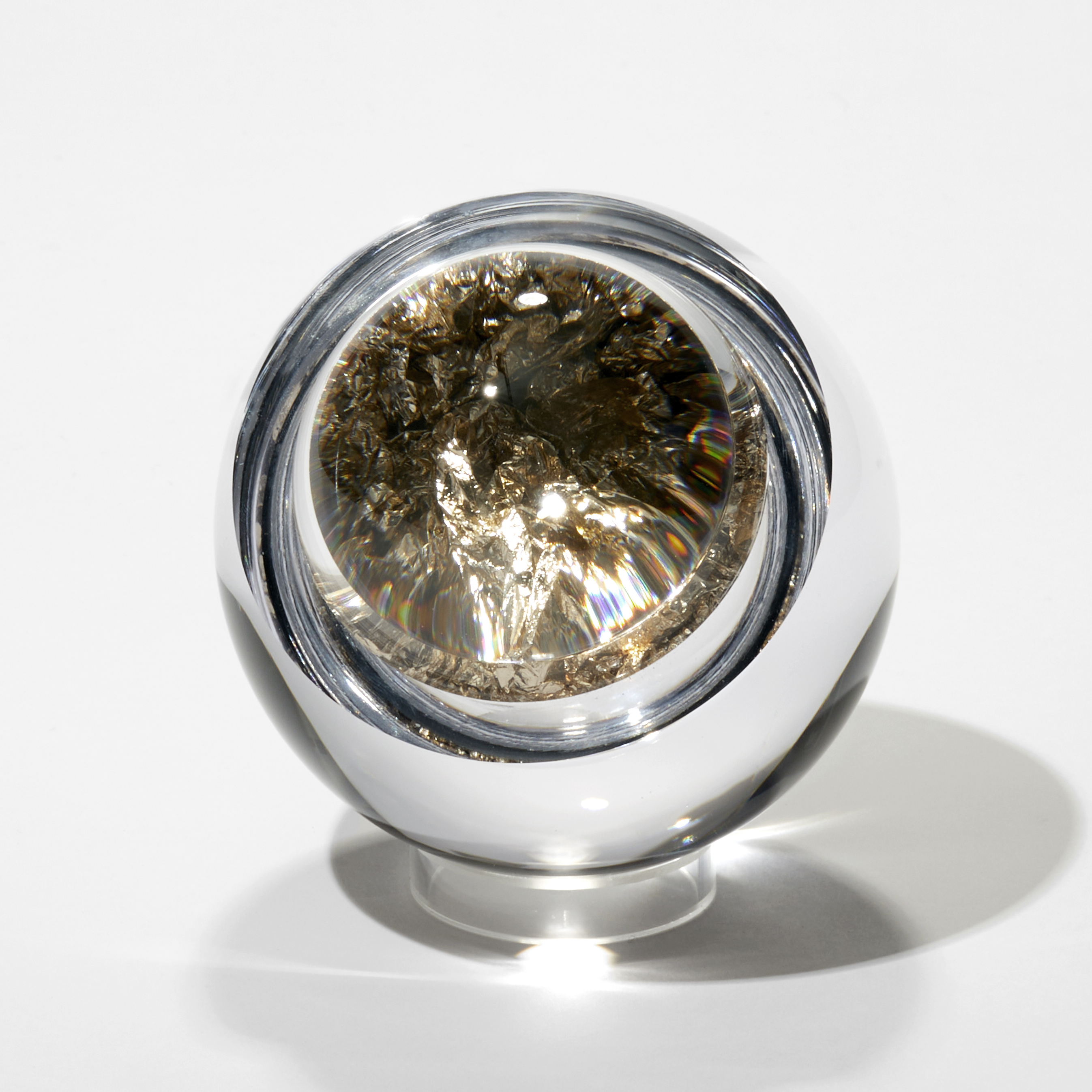 clear round orb with the centre filled with crushed moon gold leaf with a convex lid bonded on trapping the leaf inside acting as a lens and enlarging the contents hand made from blown and cut glass 