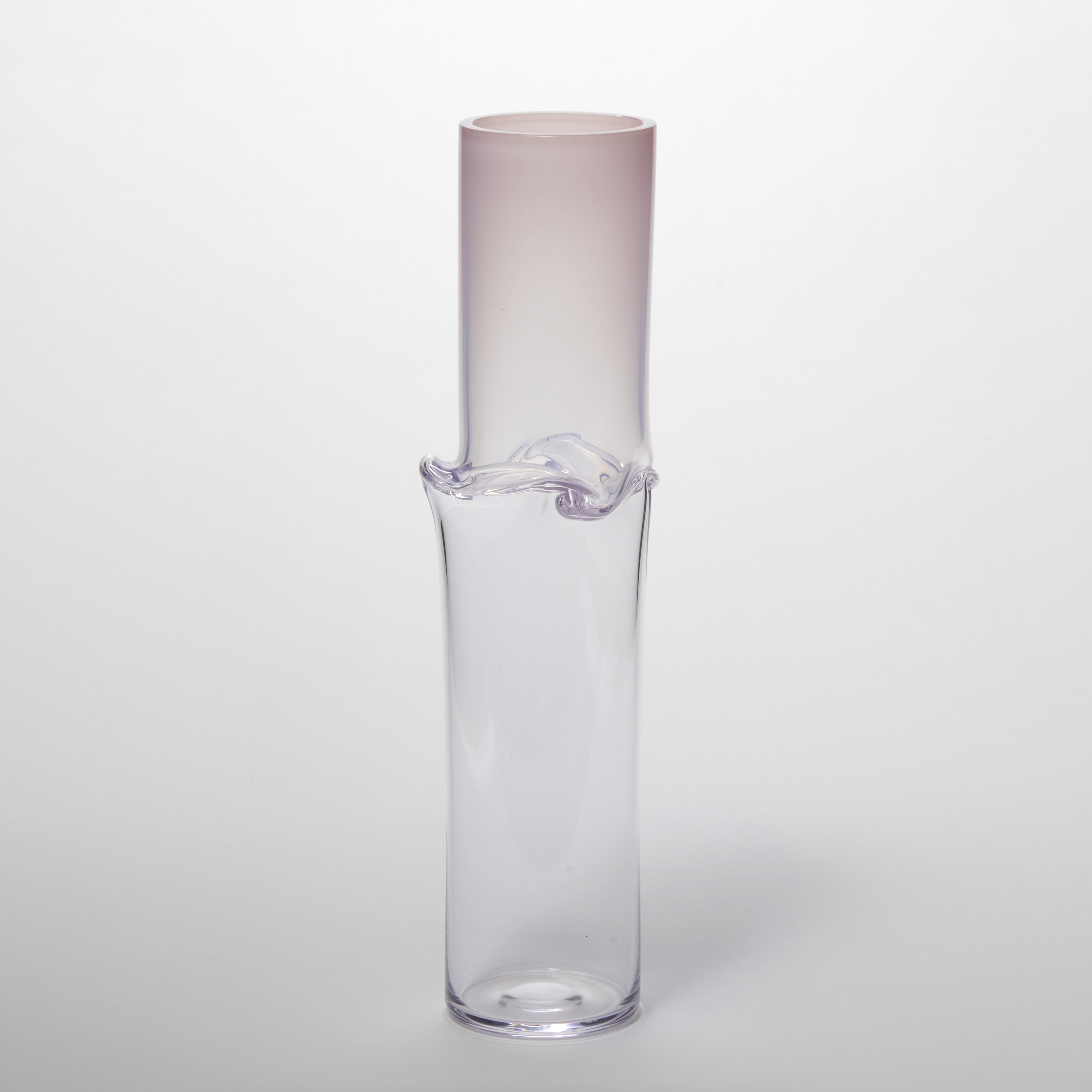 tall soft pink fading to clear cylindrical vessel with a flared and three dimensional raised creased waist hand made from glass