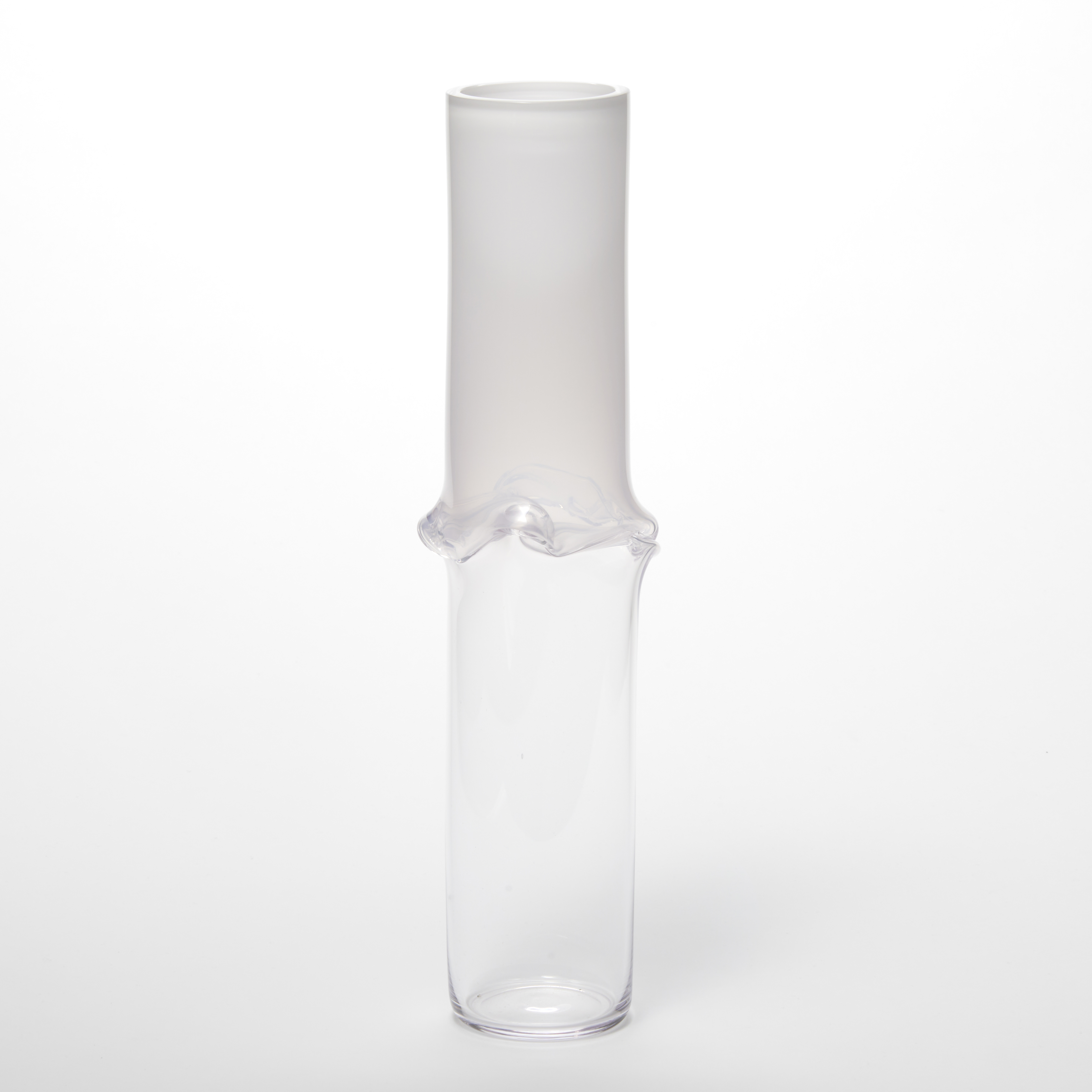 tall cylinder with soft off white top half fading to a transparent bottom half with a wavy flared creased frill in the middle hand made from glass