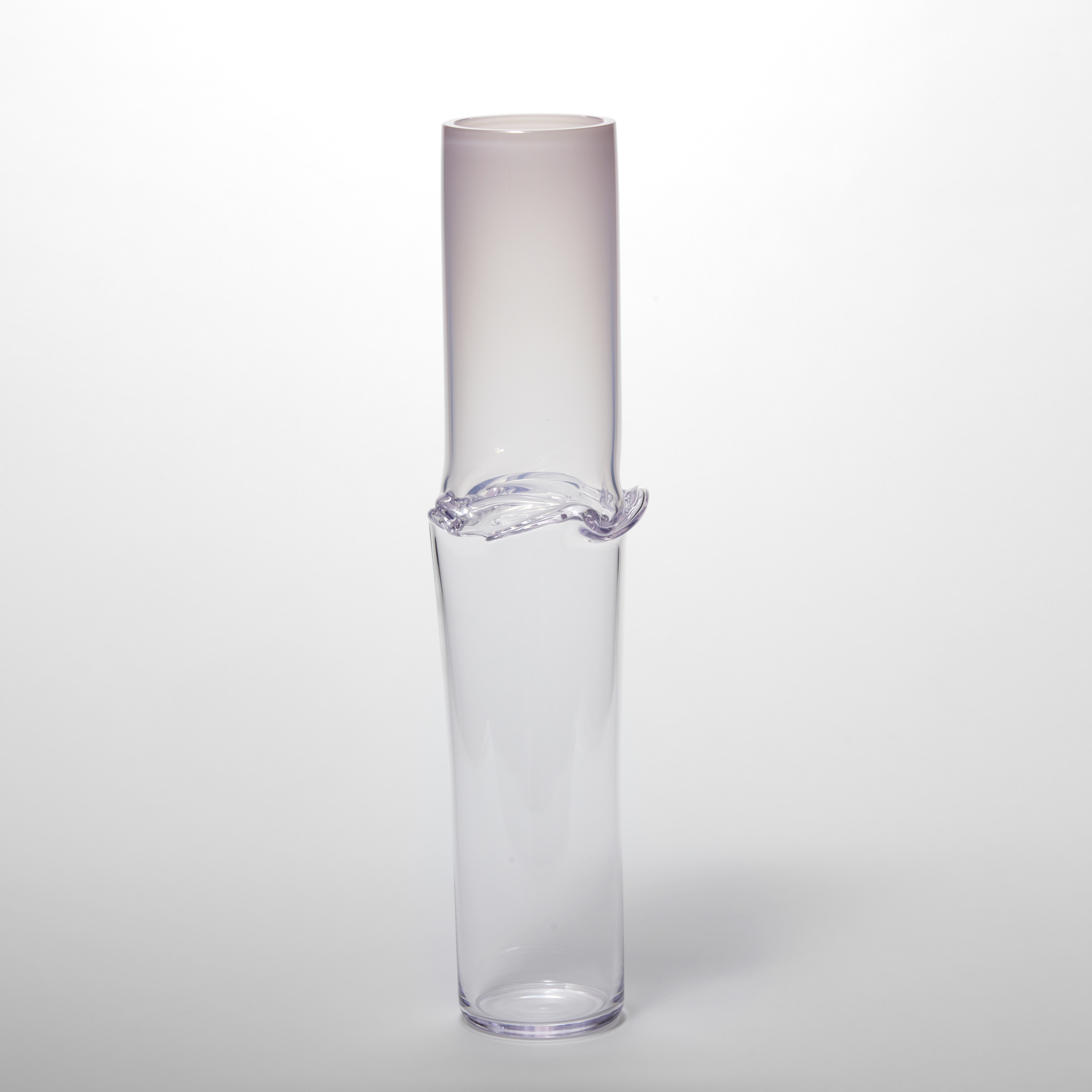 tall cylindrical vessel with soft pink top half fading to a clear bottom half with a creased and folding band around the waist hand made from glass