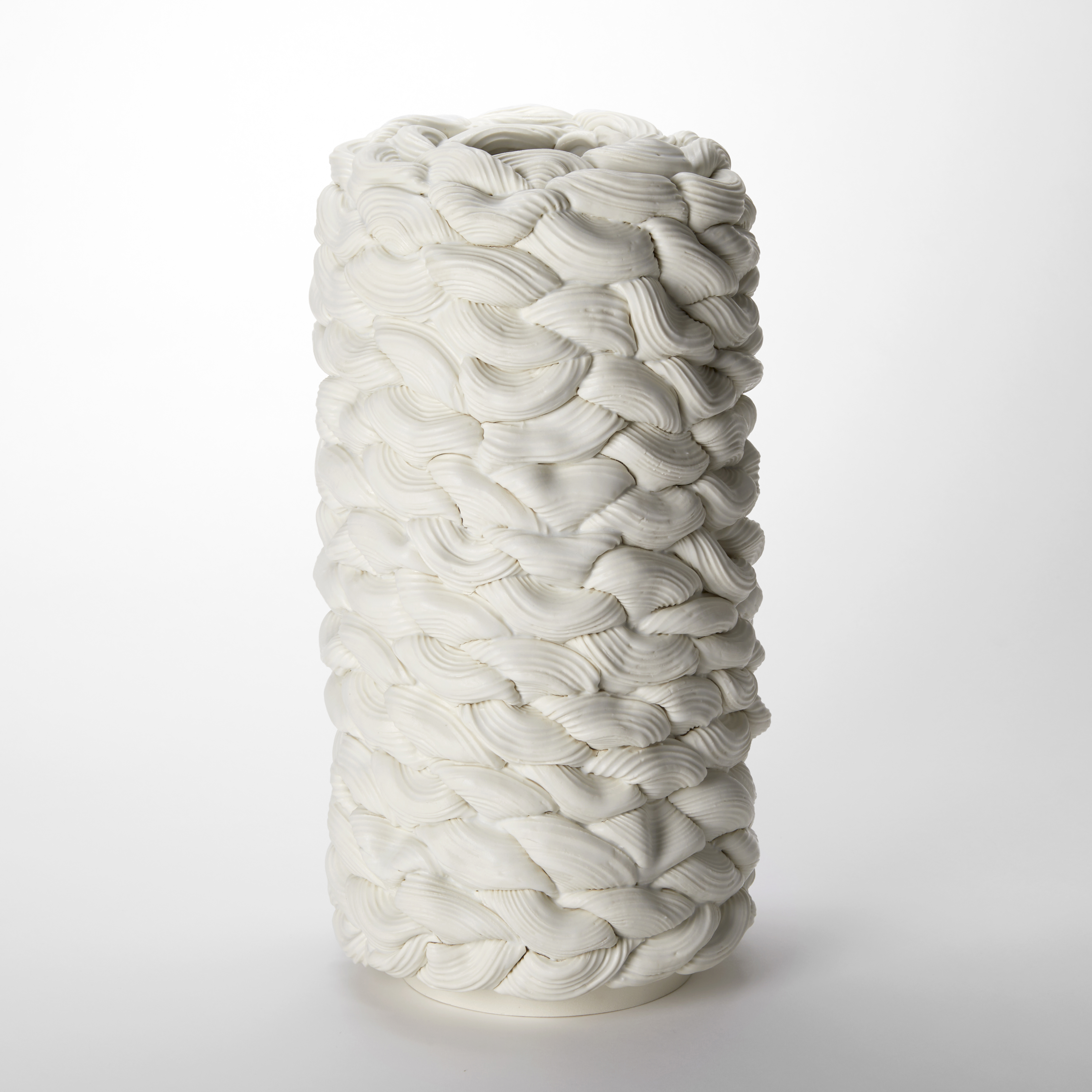 white column vessel with small opening at the top created from stacked ridged sections and rings of interwoven parian porcelain with a final glaze layer softening the entire surface hand made from parian porcelain