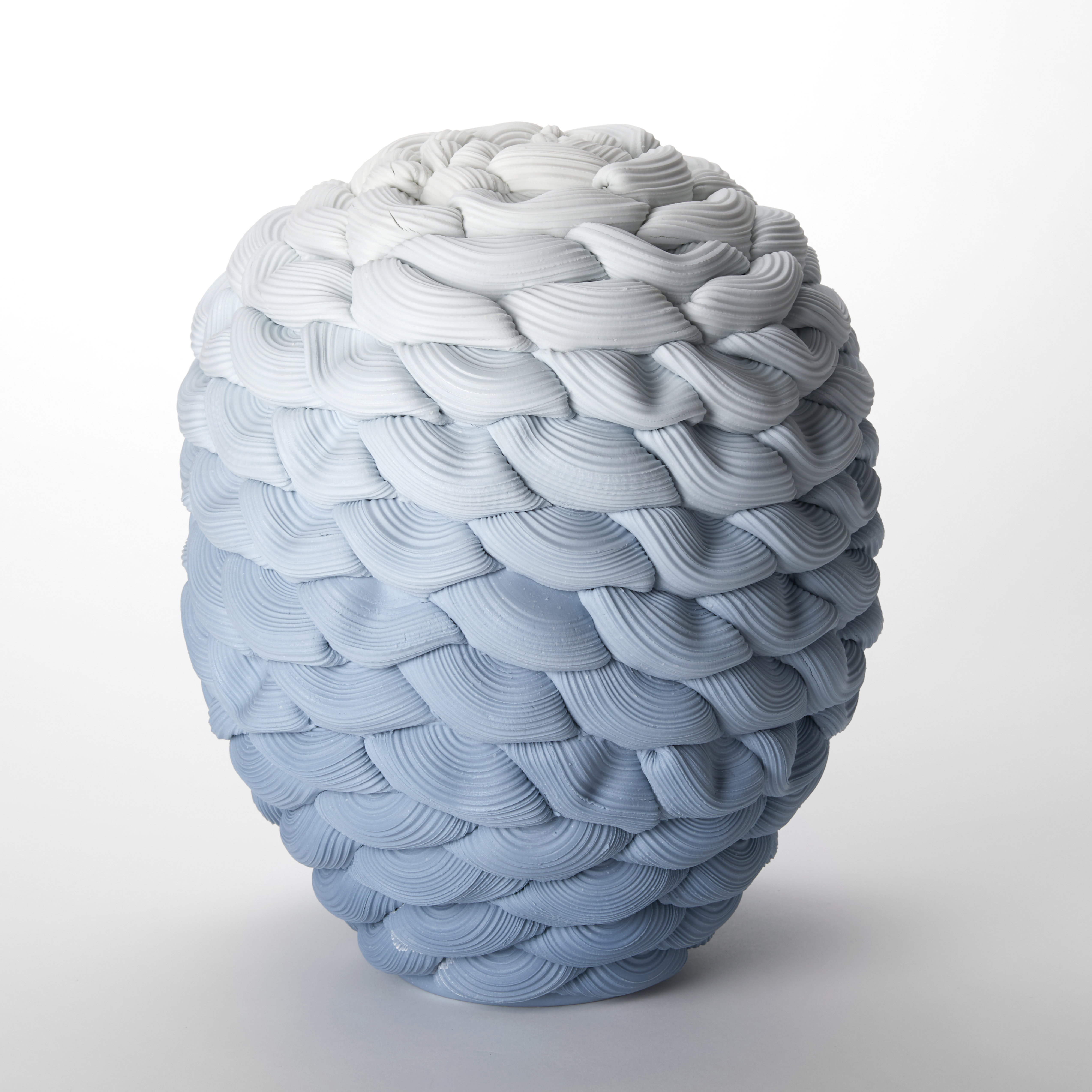 rounded vessel created from stacked ridged rings fading from dark aquamarine at the base graduating to white at the top hand made from parian porcelain