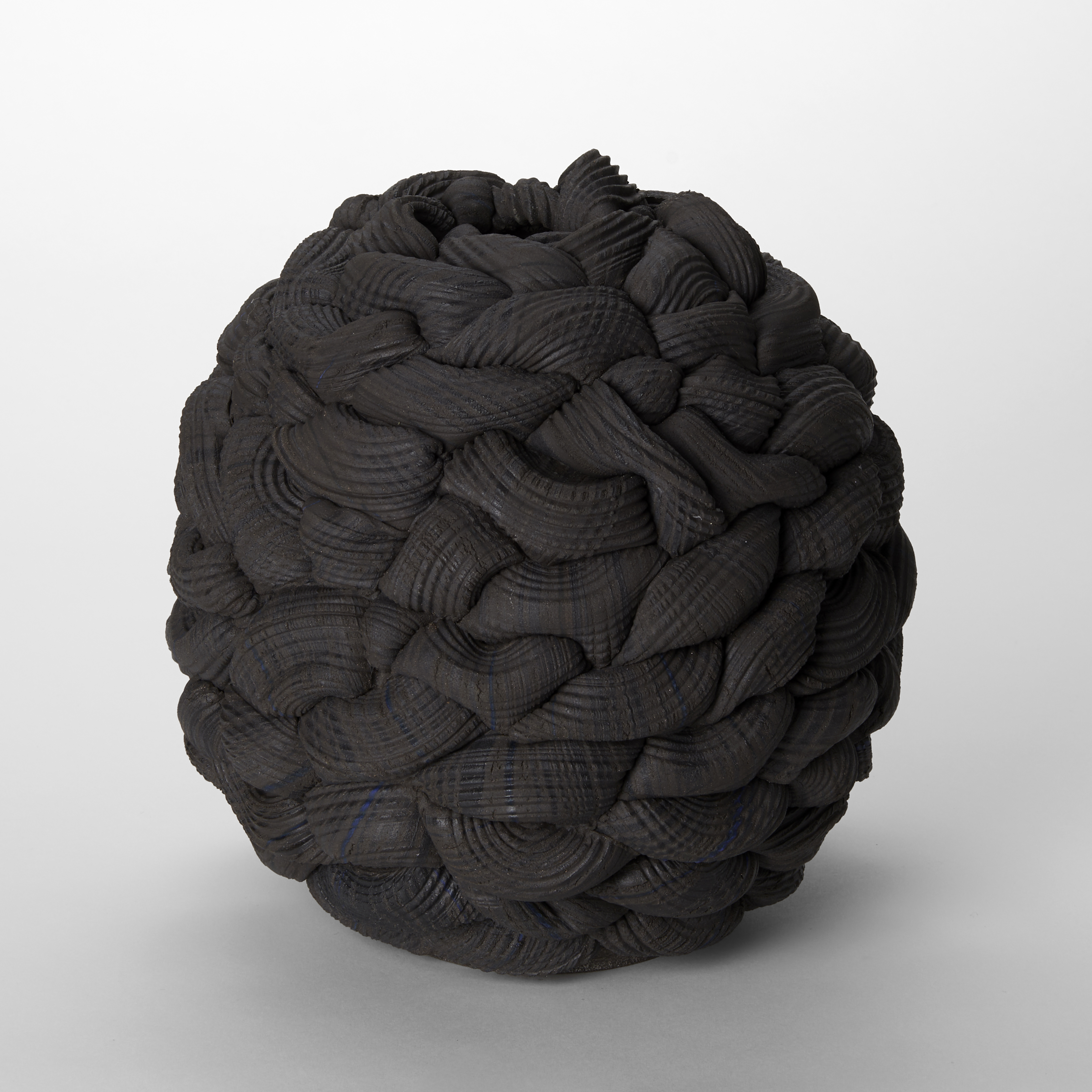 hand made round black stoneware vessel with the appearance of a ball of chunky knit wool 