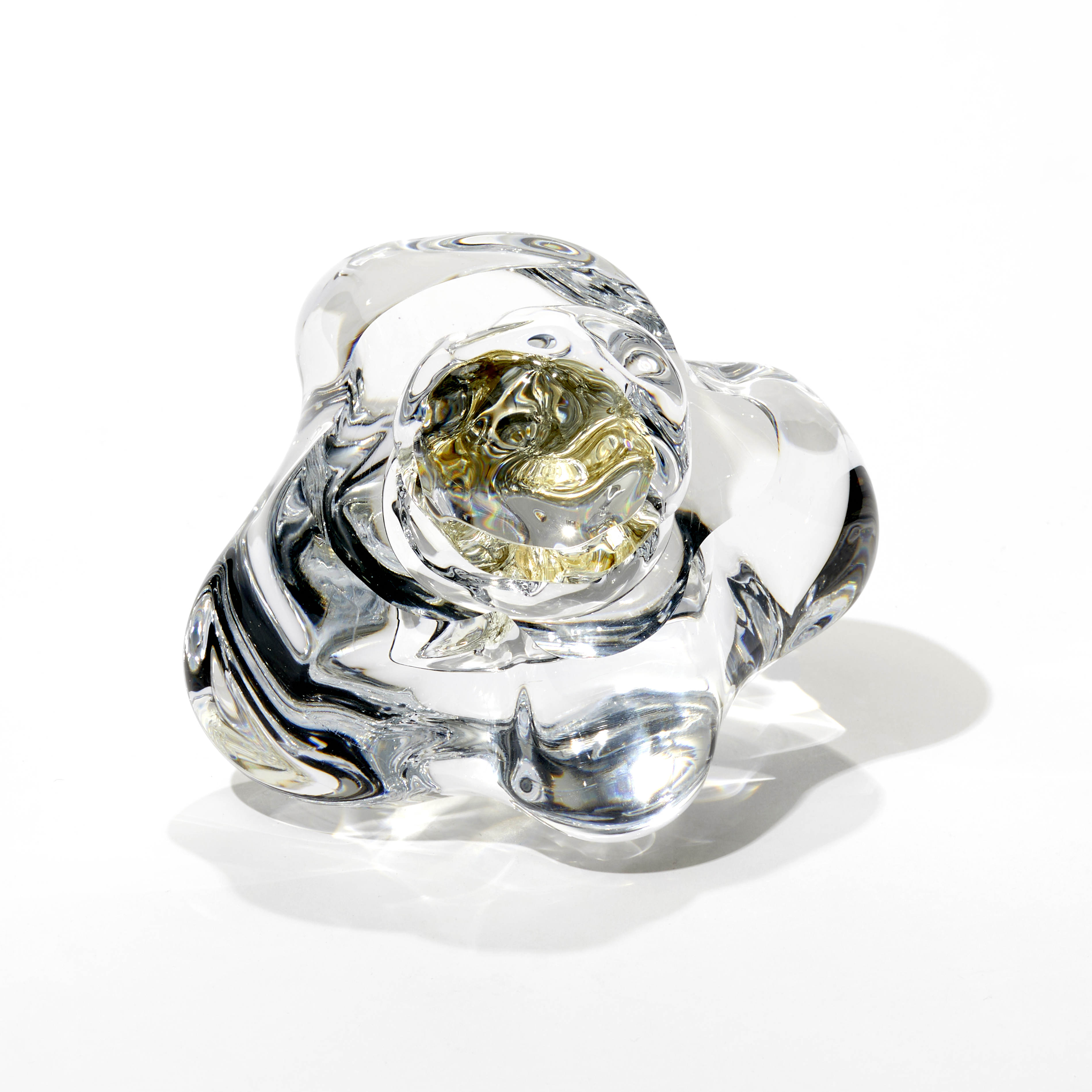 organic amorphous clear icy rock like sculpture with a central hallow filled with crushed gold leaf hand made and cut from glass