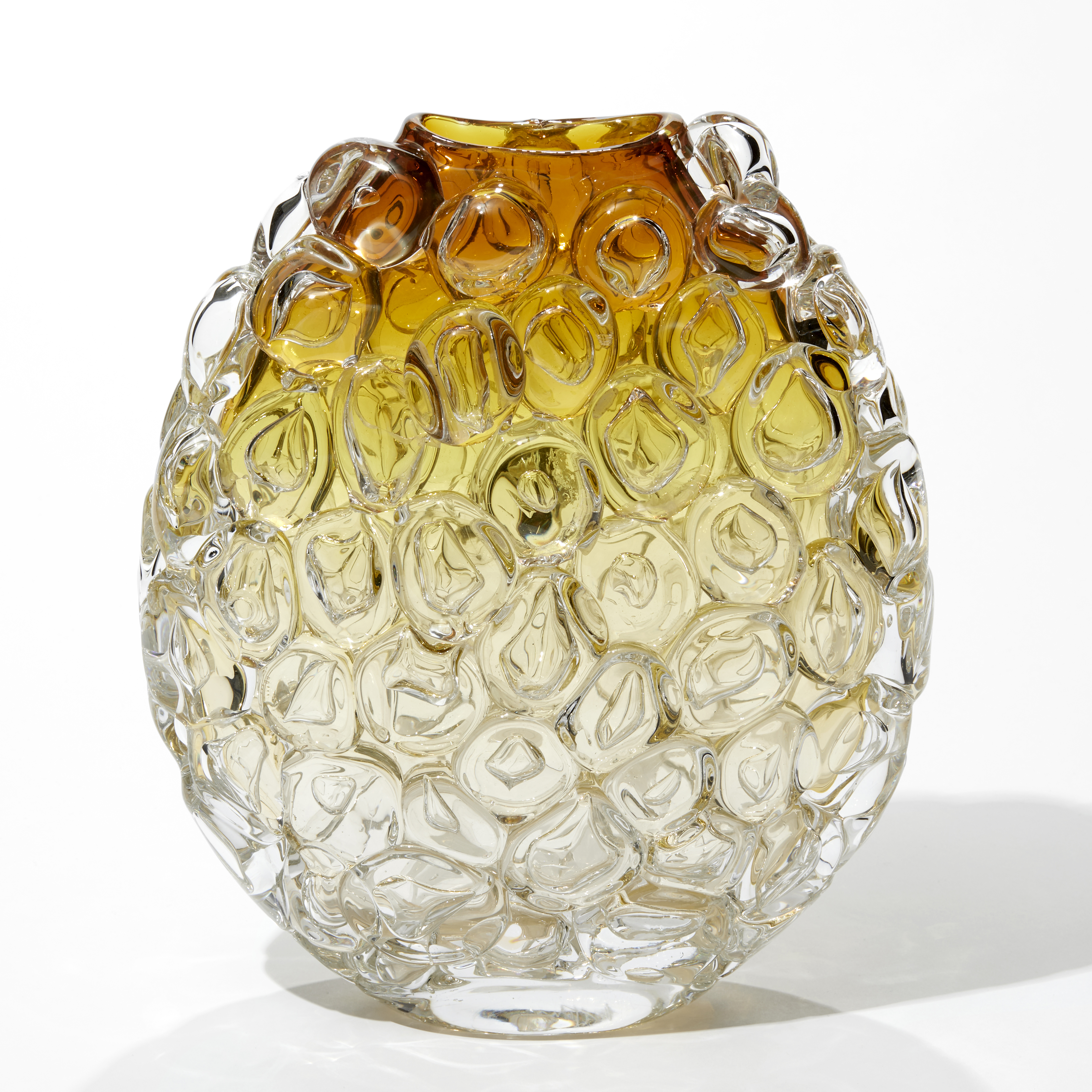ovoid rounded shaped vase with a flat front and back in clear at the base fading to rich amber at the top with the entire surface covered in large bubbles like bubblewrap packaging hand made and blown from glass
