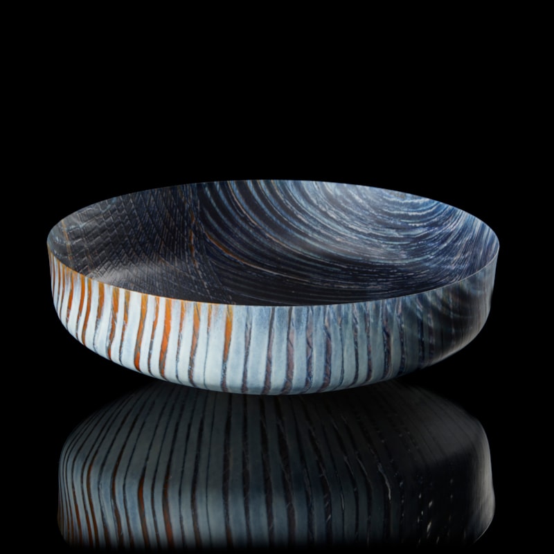 round opaque bowl in dark blue light grey and rust with organic curved lined patterns on the inside and outside hand made from fused glass