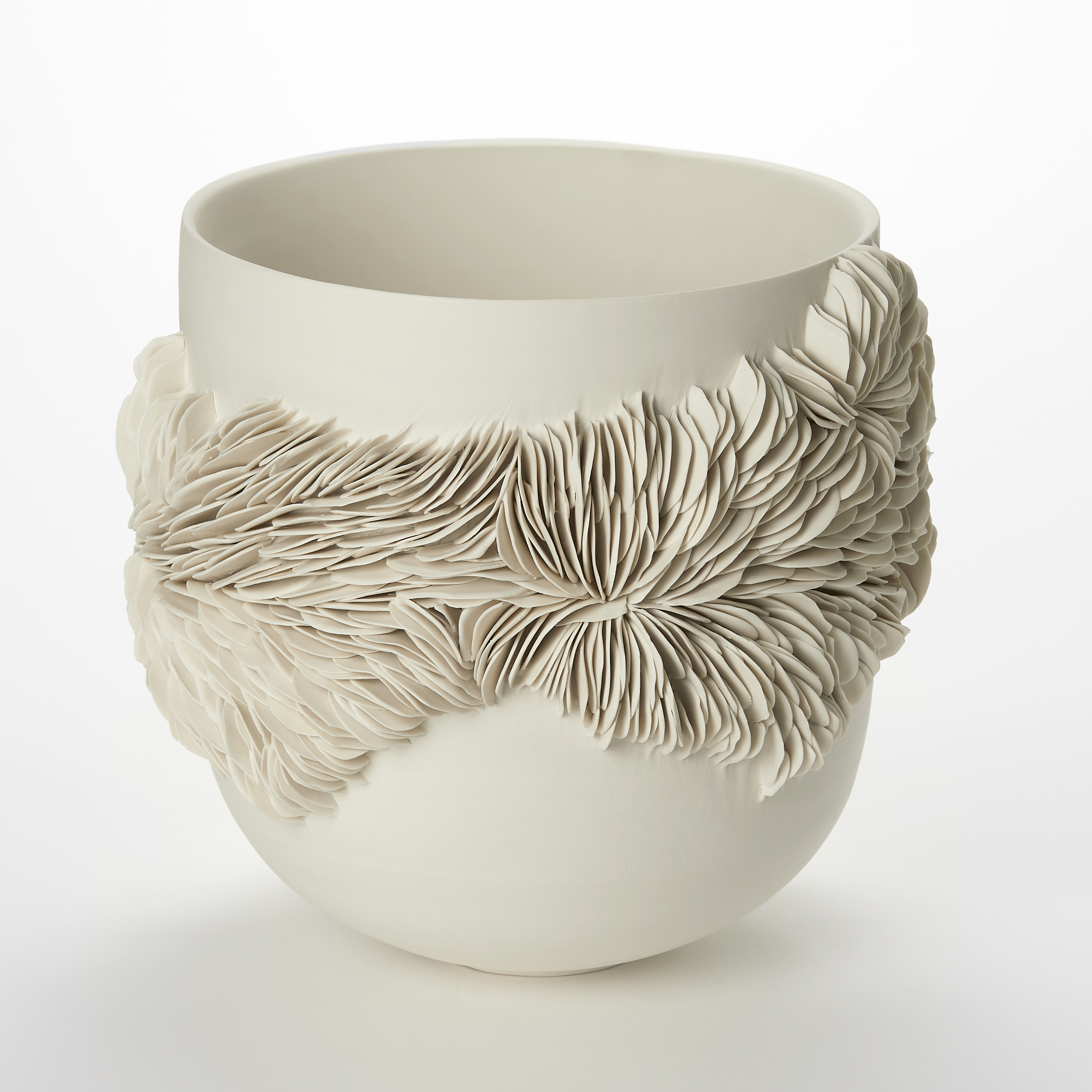 alabaster off white cream high sided bowl with a rounded base and an organic undulating band of small shards embedded and sticking out from the surface with the appearance of irregular rock strata hand made from porcelain