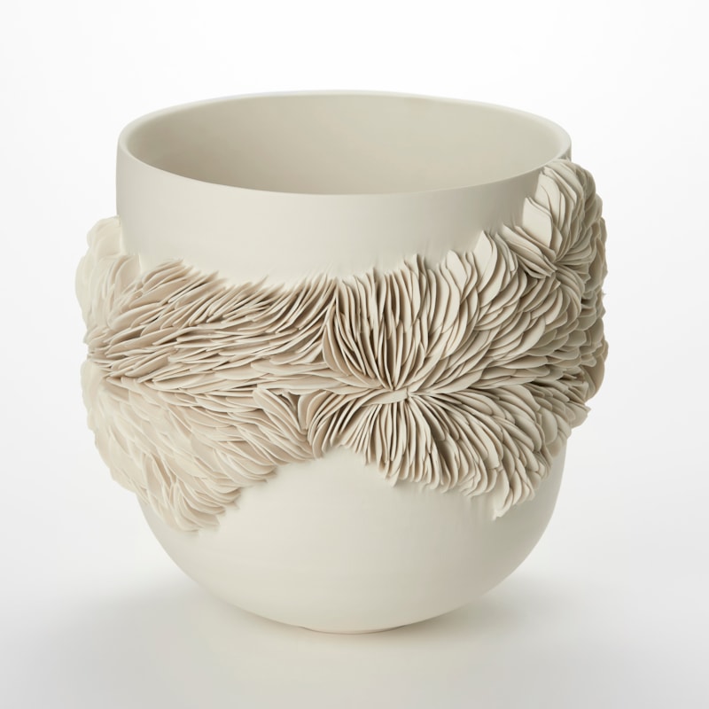 alabaster off white cream high sided bowl with a rounded base and an organic undulating band of small shards embedded and sticking out from the surface with the appearance of irregular rock strata hand made from porcelain