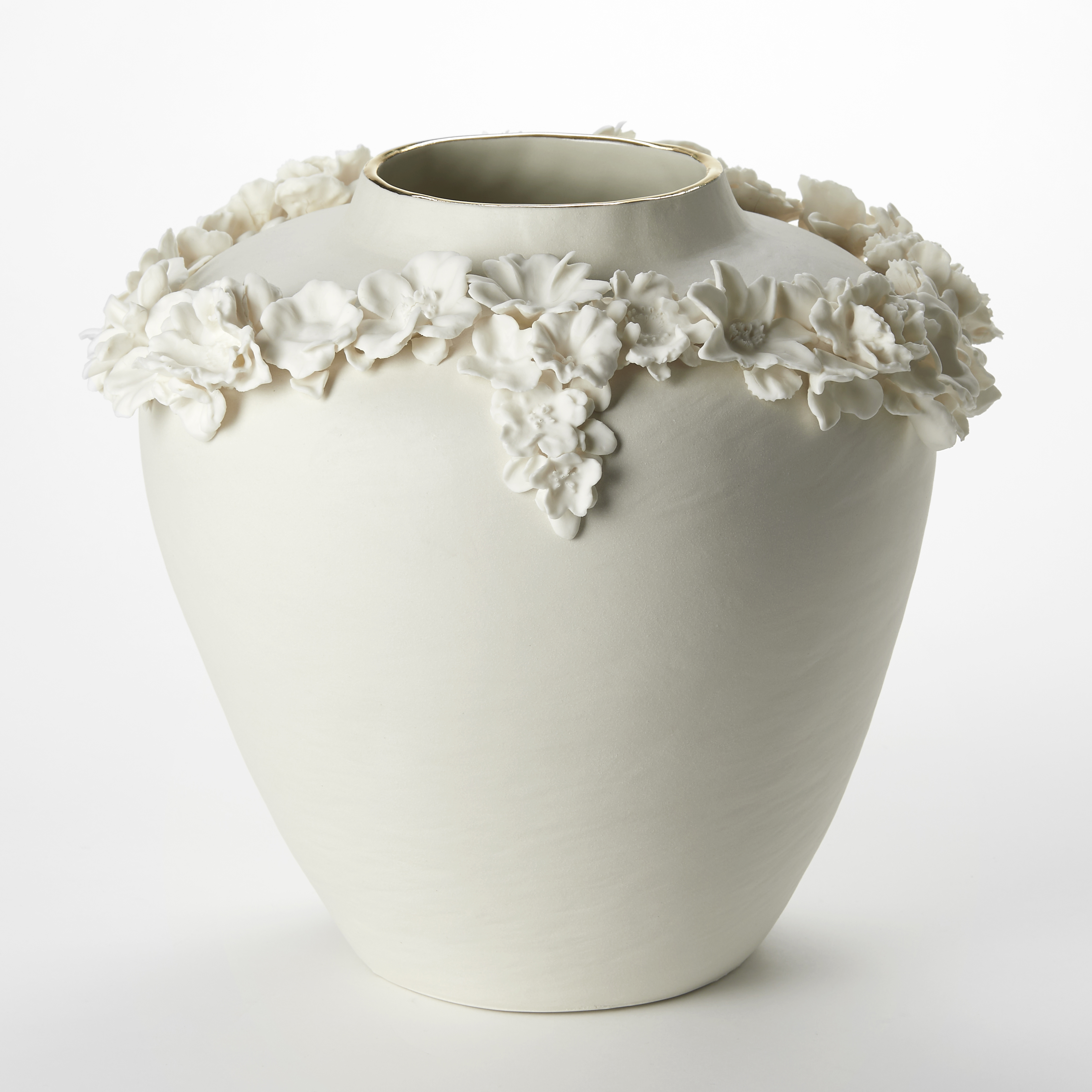 elegant off white cream rounded vase with tapering lower half and slightly raised narrowing rim on the top finished with a band of gold with the widest section encircled with a looping band of protruding flowers hand made from porcelain 