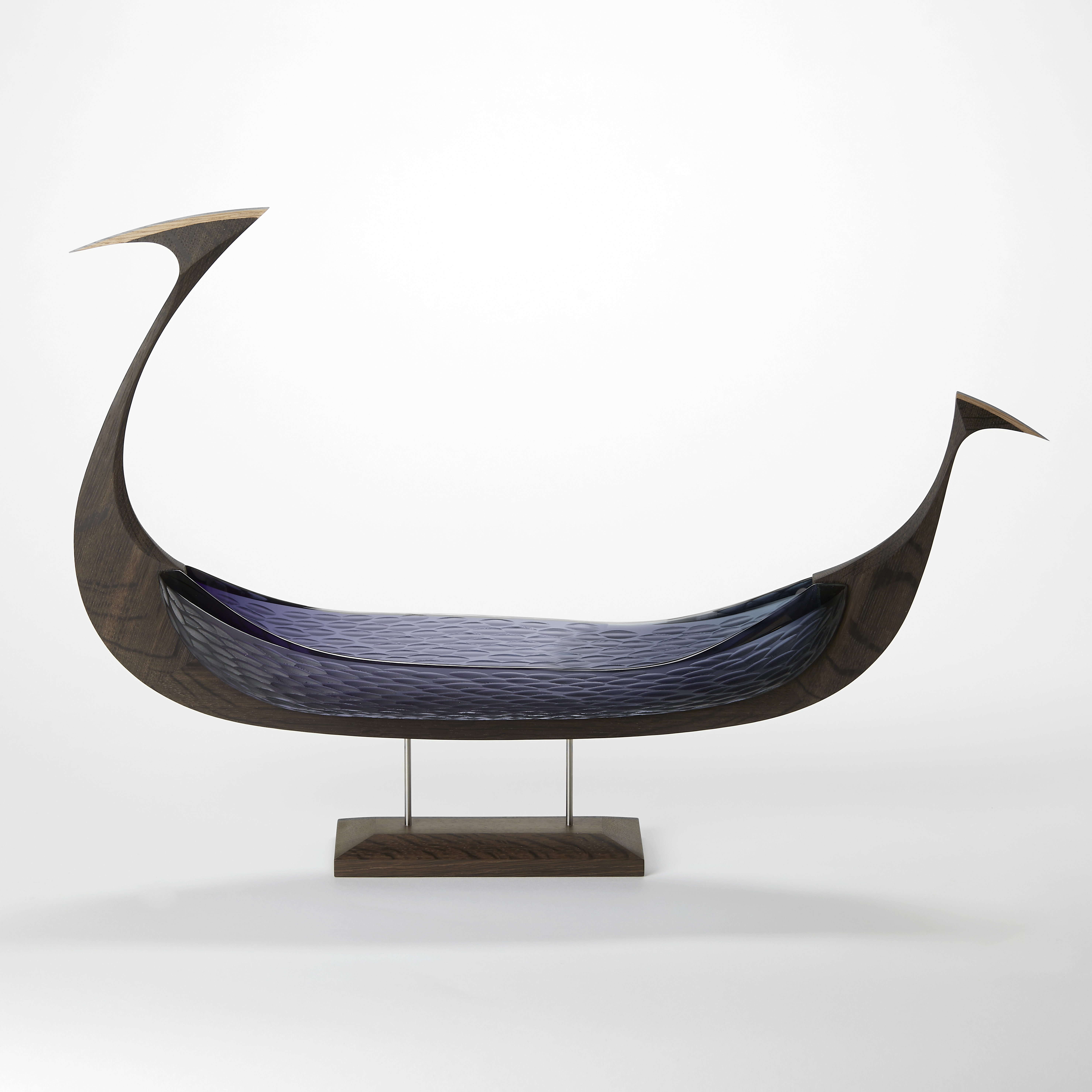 viking ship with rounded keel with pointed ends made from oak and purple hand blown glass hull with a fine scalloped patterns cut on the surface