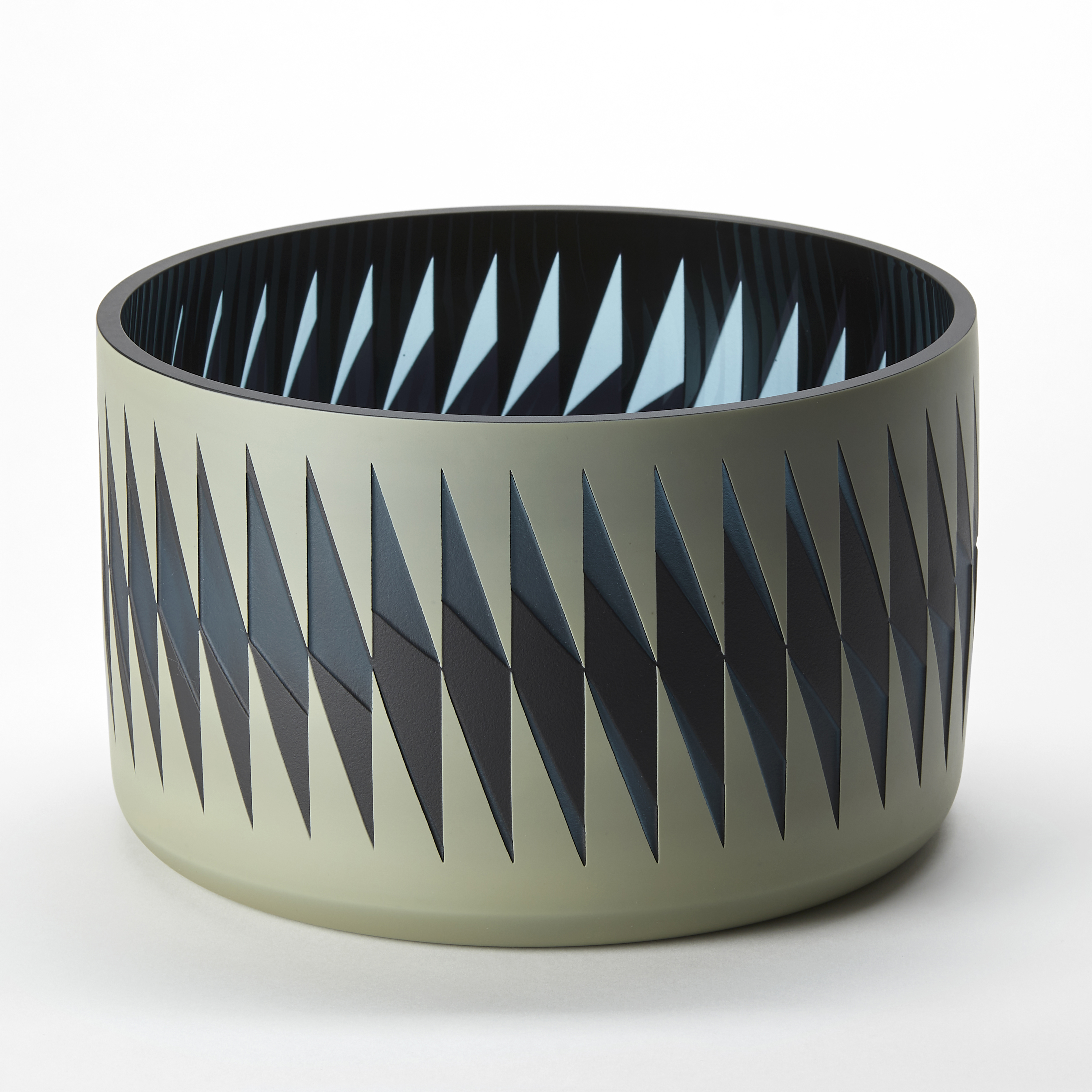 low round vase with a matt khaki green exterior and shiny blue and aqua interior with a repeat diamond pattern following the circumference in glossy black and transparent blue hand made from blown glass