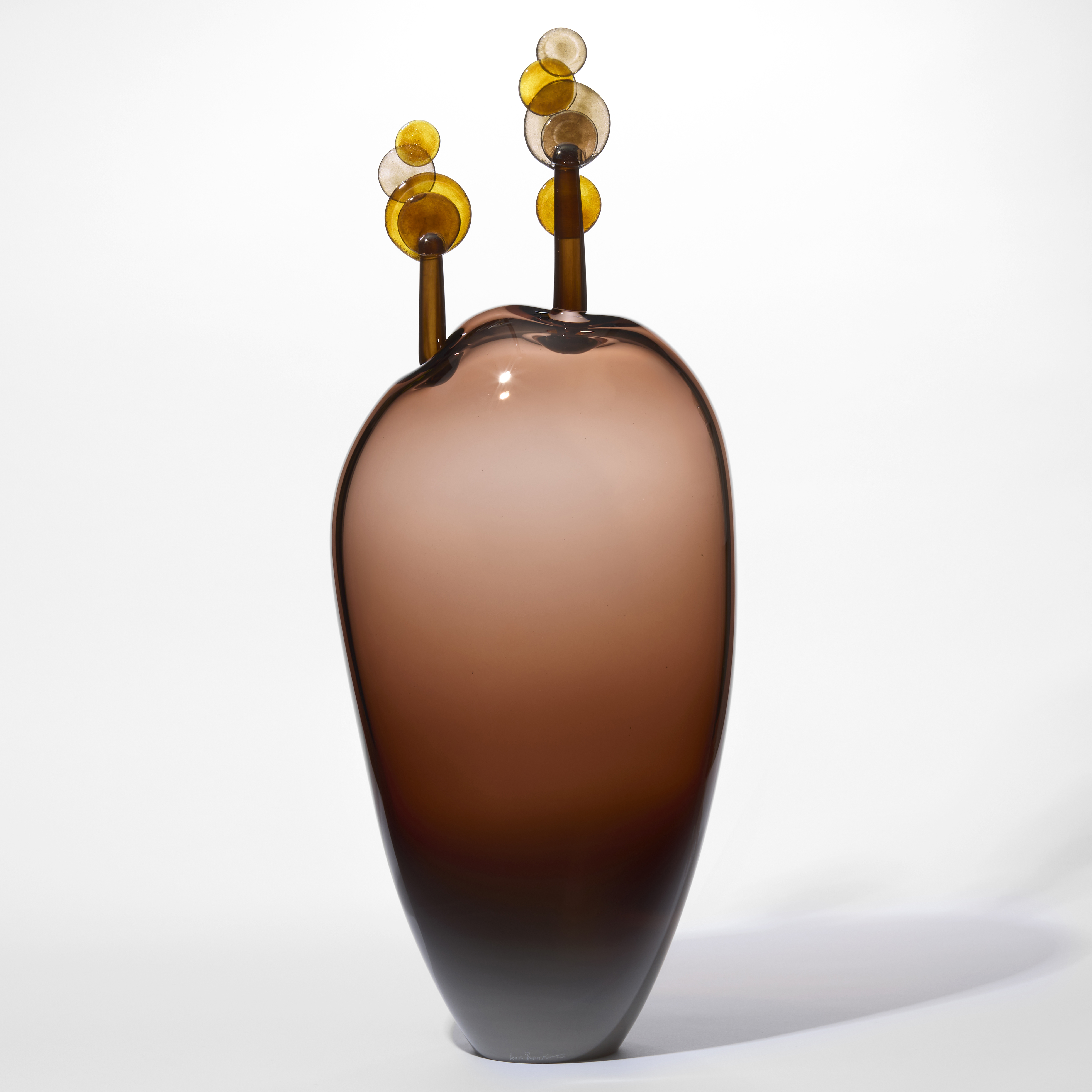 tall amorphic transparent aubergine brown form with a dark base fading towards the top with two simple lollipop trees perched on the top in dark brown and amber hand made from glass