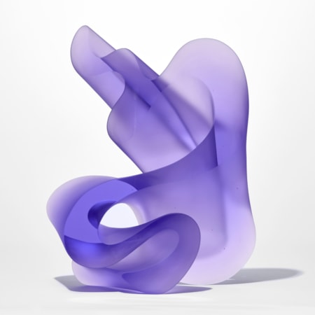three dimensional standing form with a flat front and back with undulating and curling sides in semi transparent purple hand made from glass
