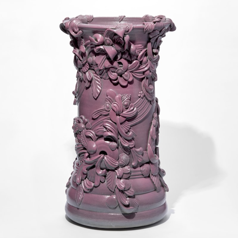 tall architectural column shaped vase with swirls and flourishes attached and encircling the exterior hand thrown from white saint thomas clay with a soft satin sheen rich dark pink glaze