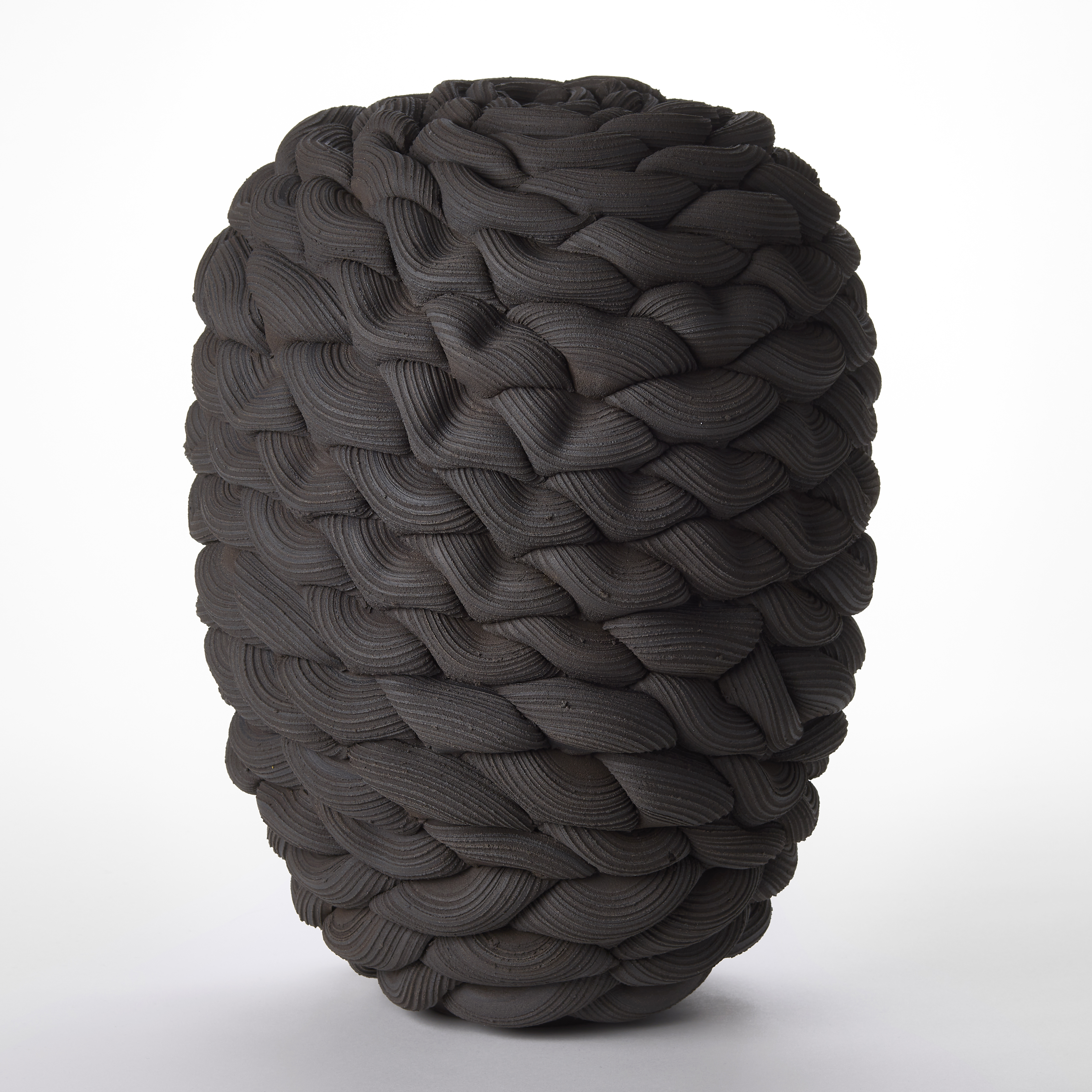 tall stocky standing matt black rounded oval vessel created from stacked interwoven ridged loops hand made from stoneware clay and parian