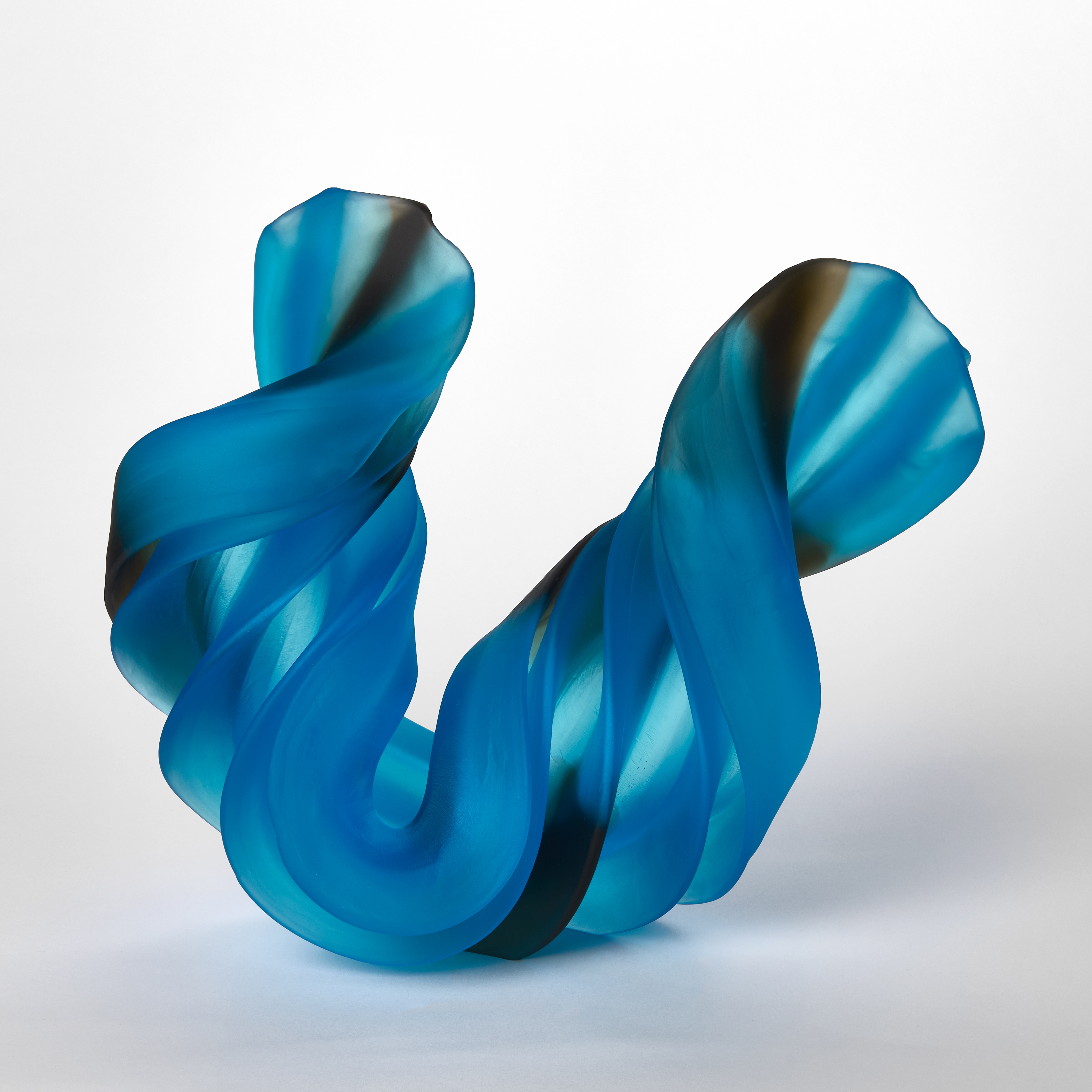 curling and twisting ridged thick u shaped sculpture in semi transparent blue and black hand made from glass