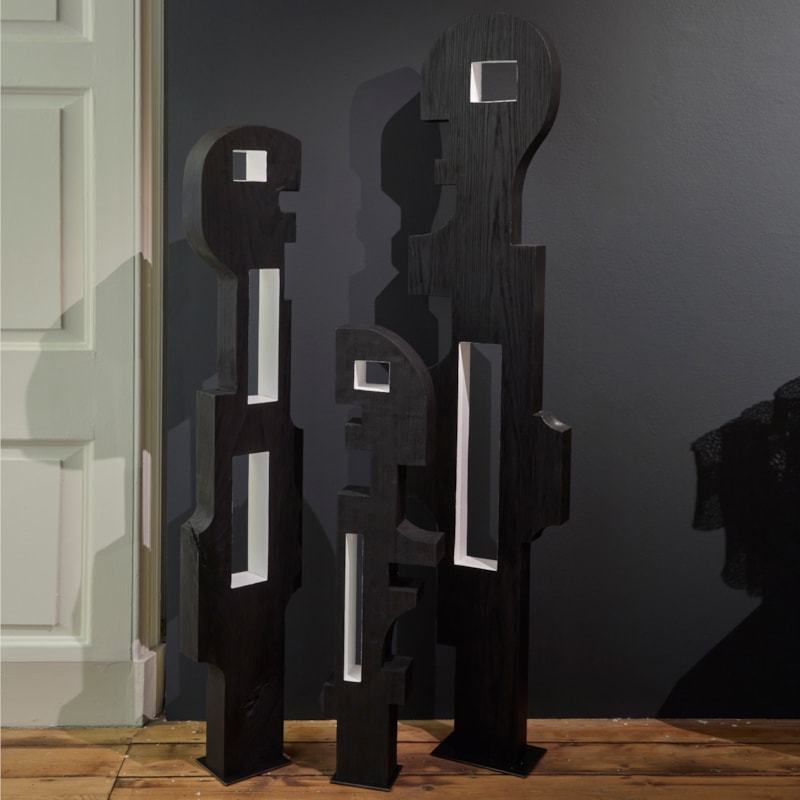 black wooden standing abstract figurative sculpture with cutout square and rectangular holes through the middle coloured white hand made and carved from ash