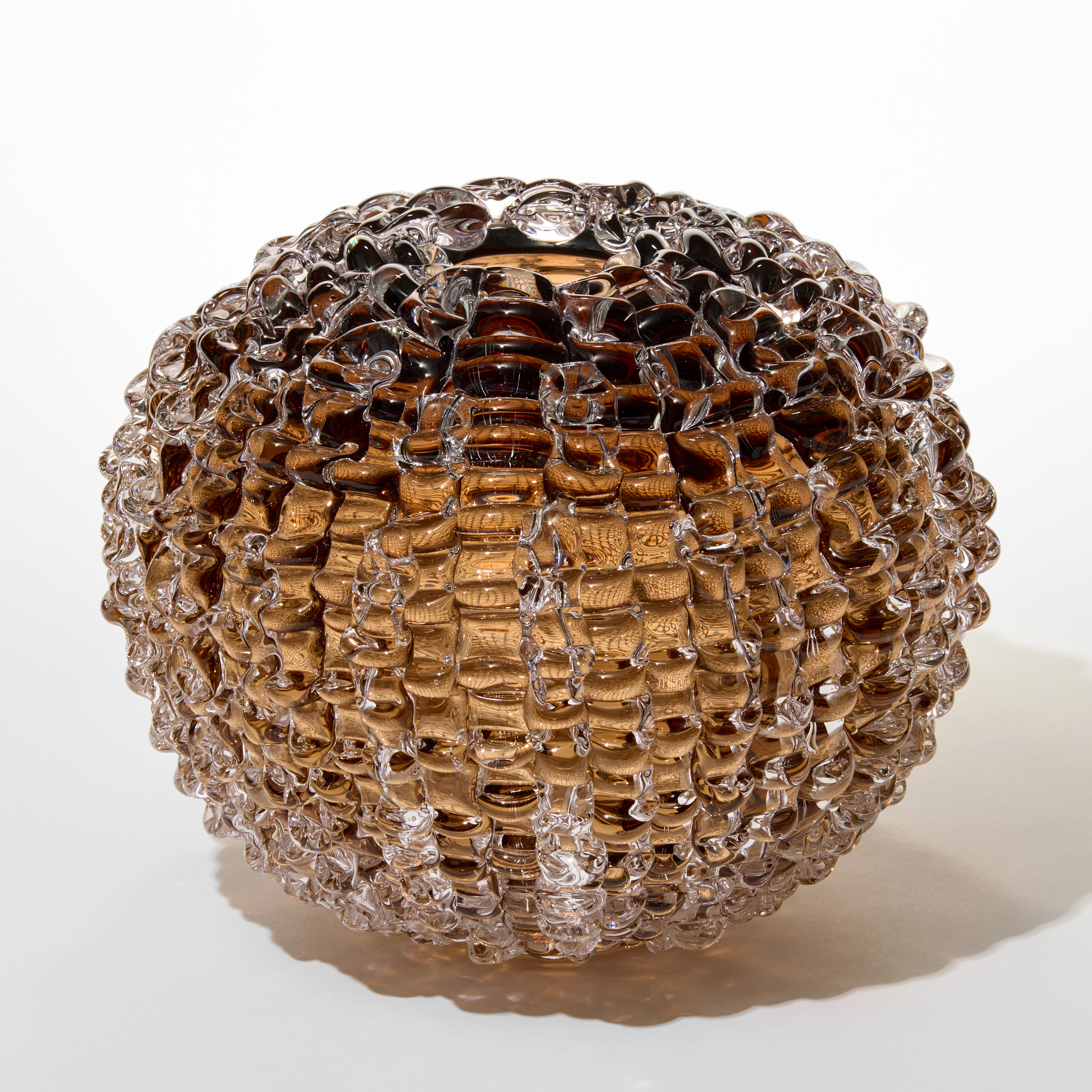 tobacco tea transparent round ball shaped vase with small top opening and the outer surface covered in raised ridged undulating lines hand made from glass