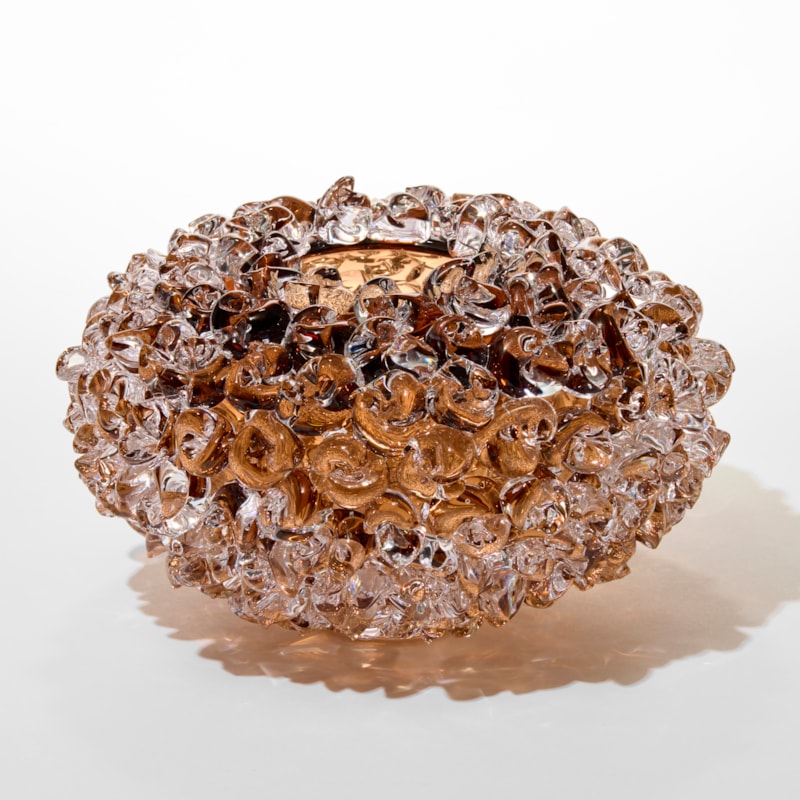 tea tobacco transparent low round vase with a small top opening and outer surface covered in twisted raised chunky dots and knots hand made from blown glass hand