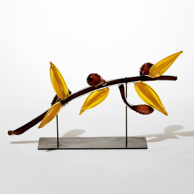 curved glossy dark brown stem with five long rounded pointed bright yellow floral leaves and four bulbous dotted prickly pear forms attached hand made from glass