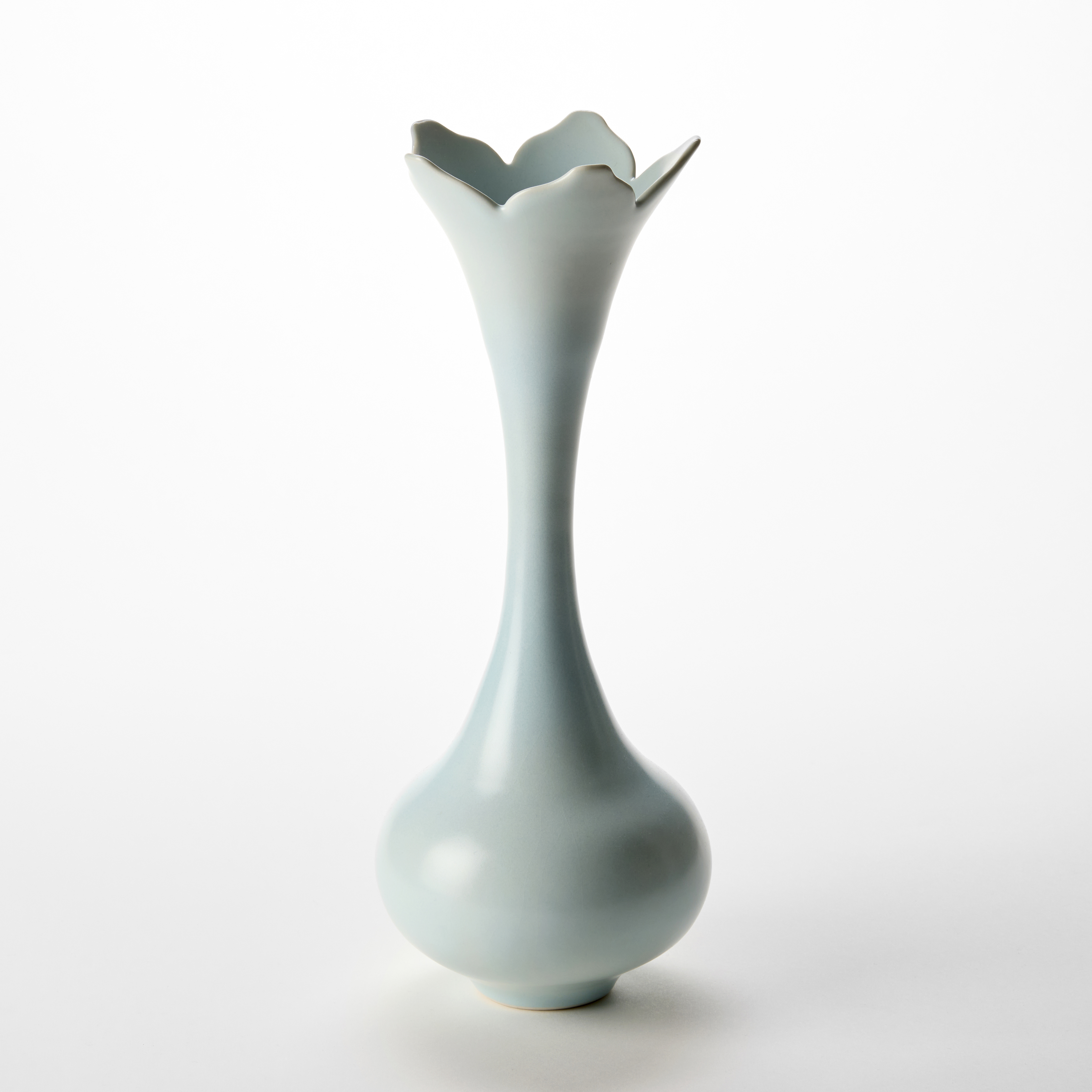 tall soft turquoise vase with low rounded base long thin elegant neck flaring to a five pointed flower shaped rim hand made from porcelain