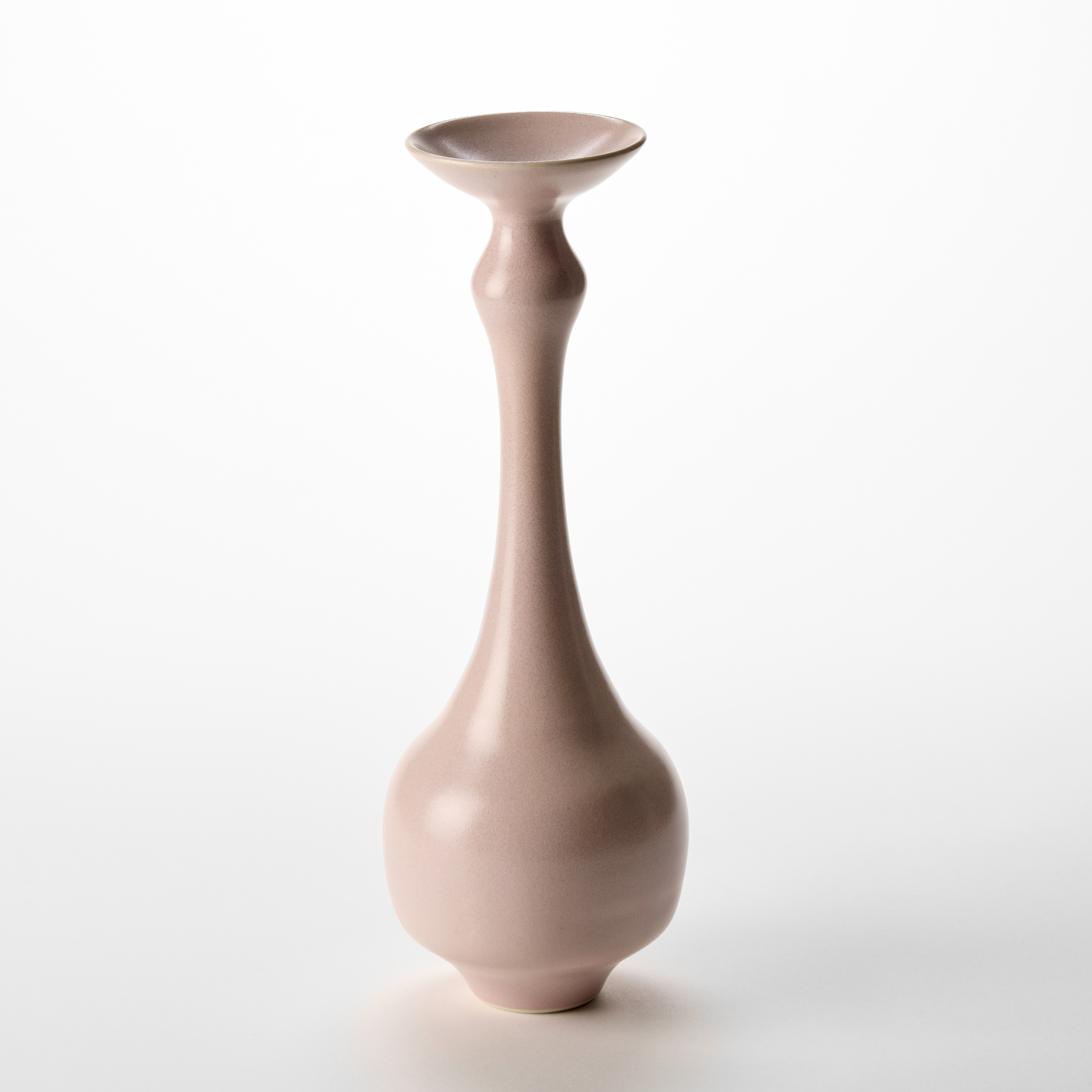 tall elegant pink vase with rounded base and long thin neck with a disc shaped flared top rim hand made from porcelain