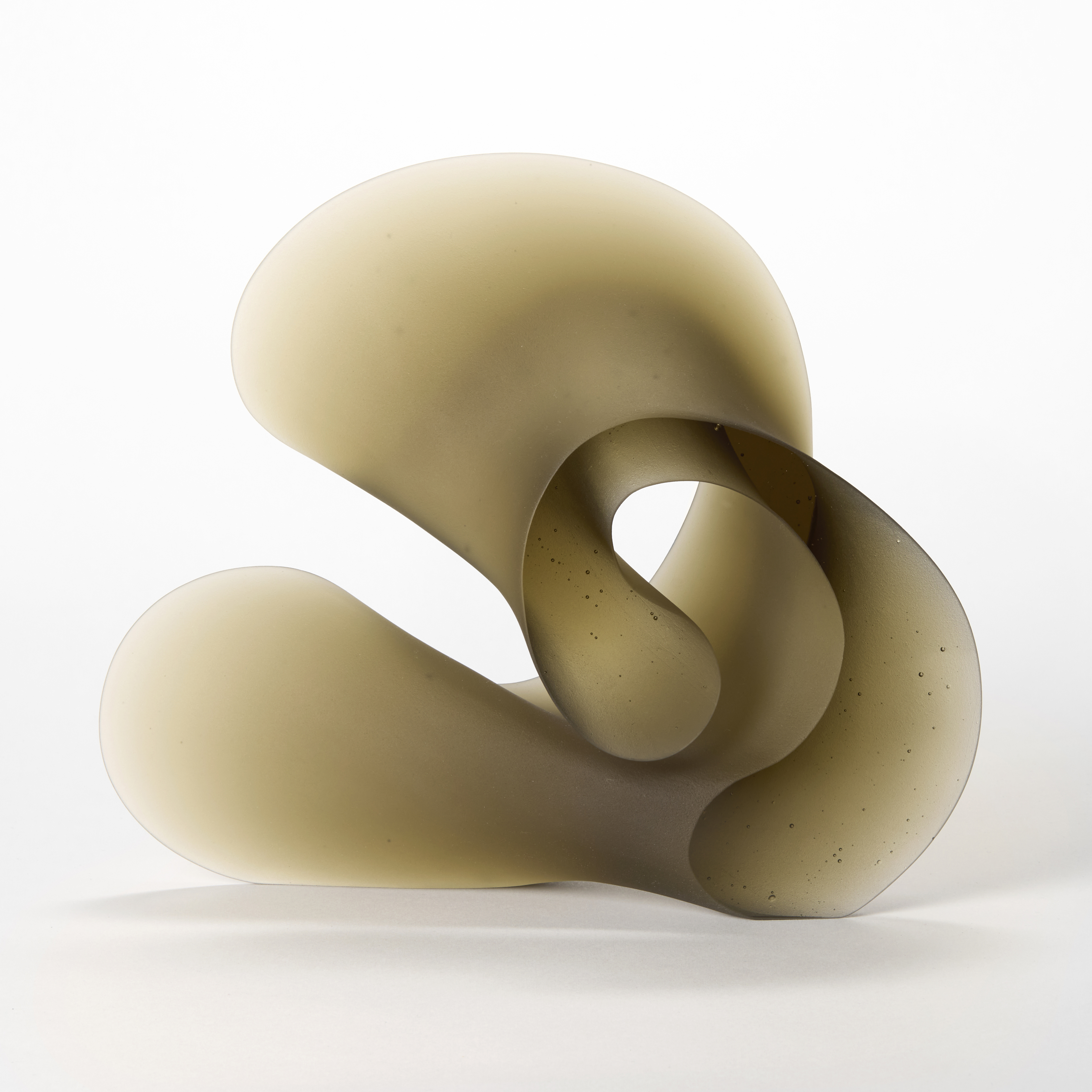 curling opaque bronze brown abstract sculpture with a shiny front and back and frosted widening side tapering to a thin edge hand made from cast glass 