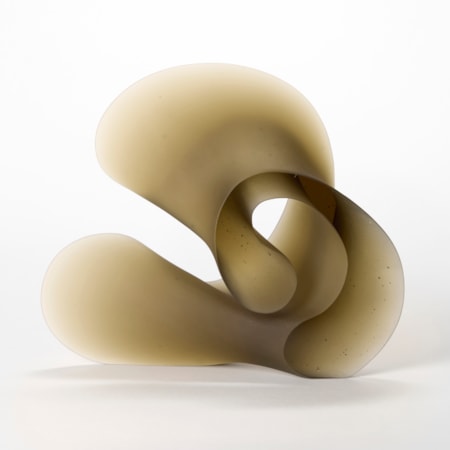 curling opaque bronze brown abstract sculpture with a shiny front and back and frosted widening side tapering to a thin edge hand made from cast glass