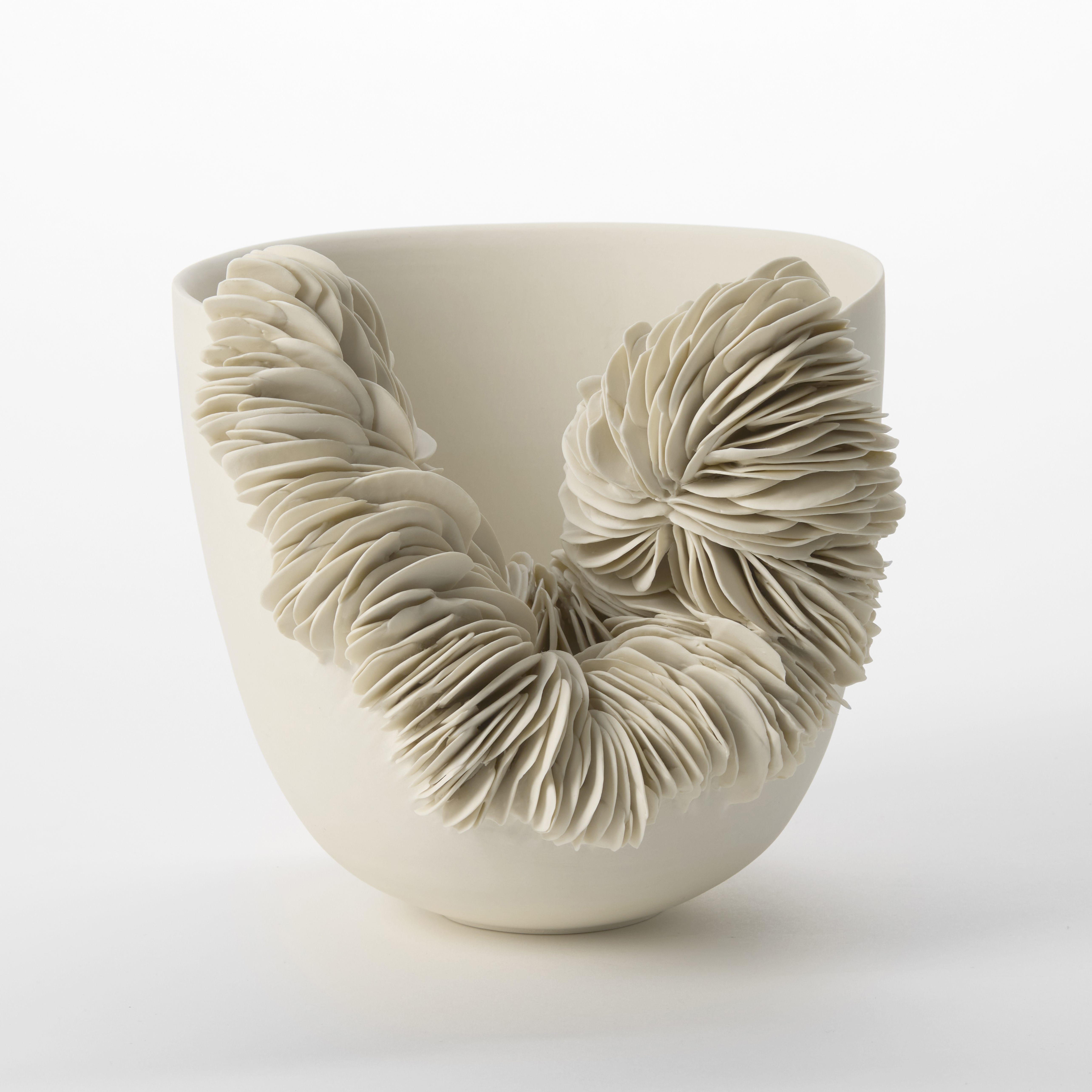 hand thrown porcelain rounded bowl with flaring tall side and large front section cut away and removed with the gap lined with stacked shards